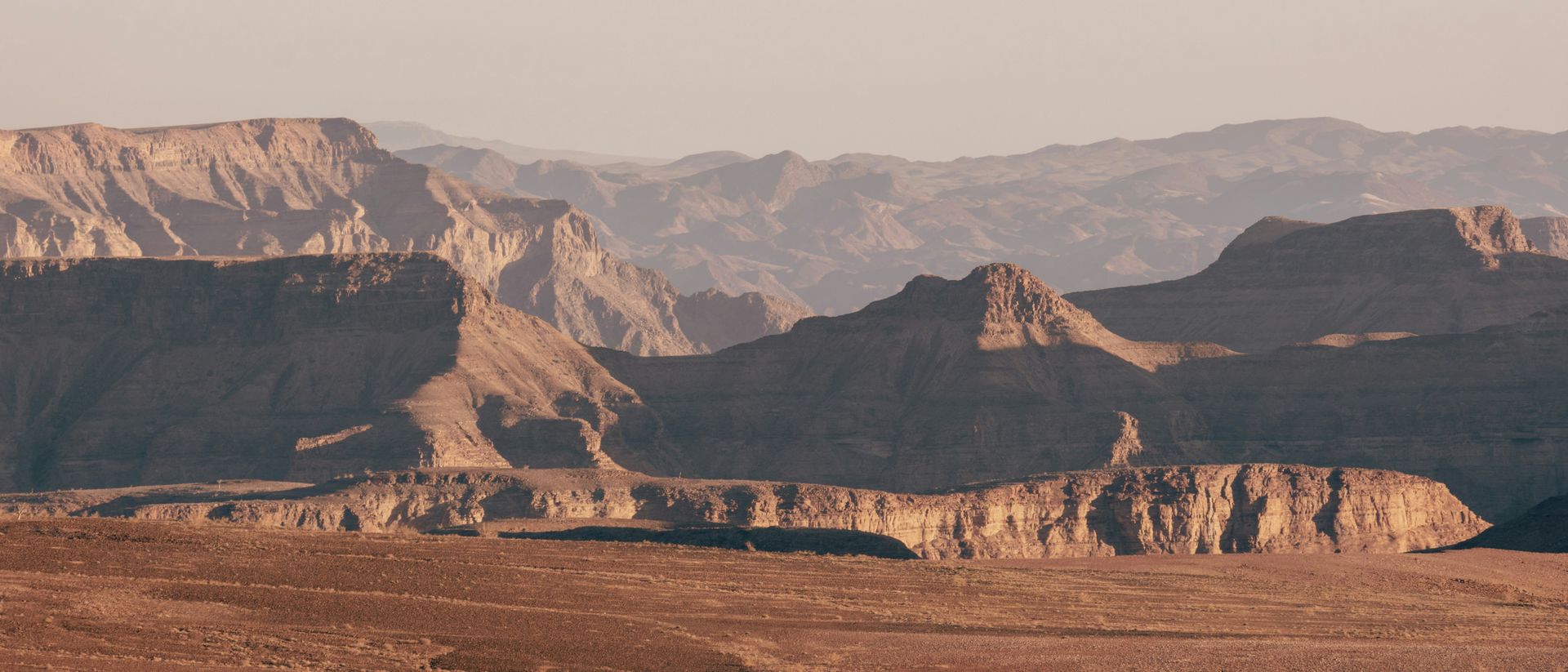 Panoramic view of a Fish River Canyon with layered brown mountains in Namibia.