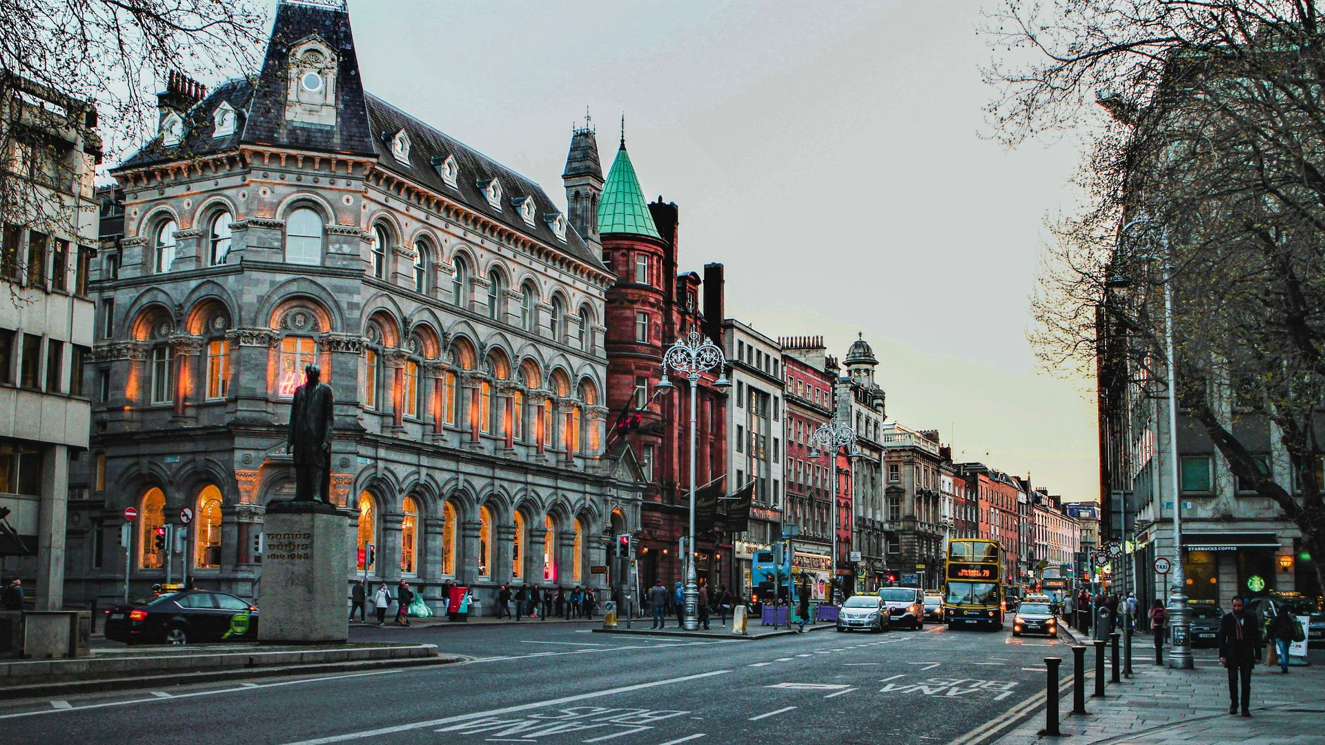 Street view of Dublin, Ireland with historic buildings, statues, and traffic.