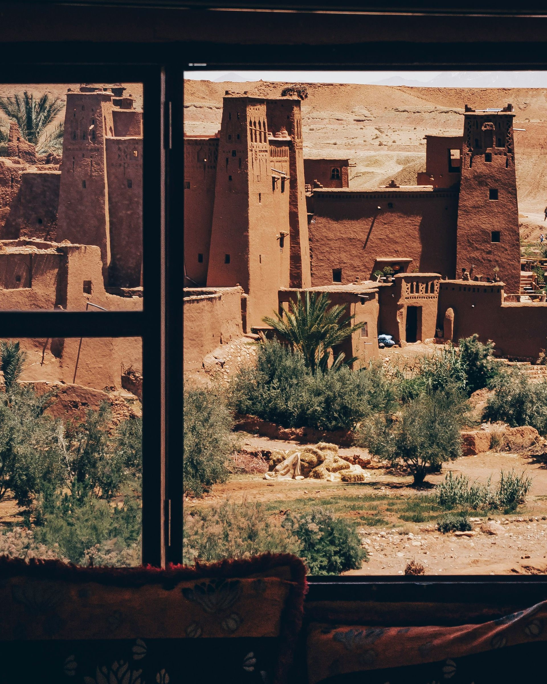 A window with a view of a castle in the desert in Ouarzazate, Morocco.