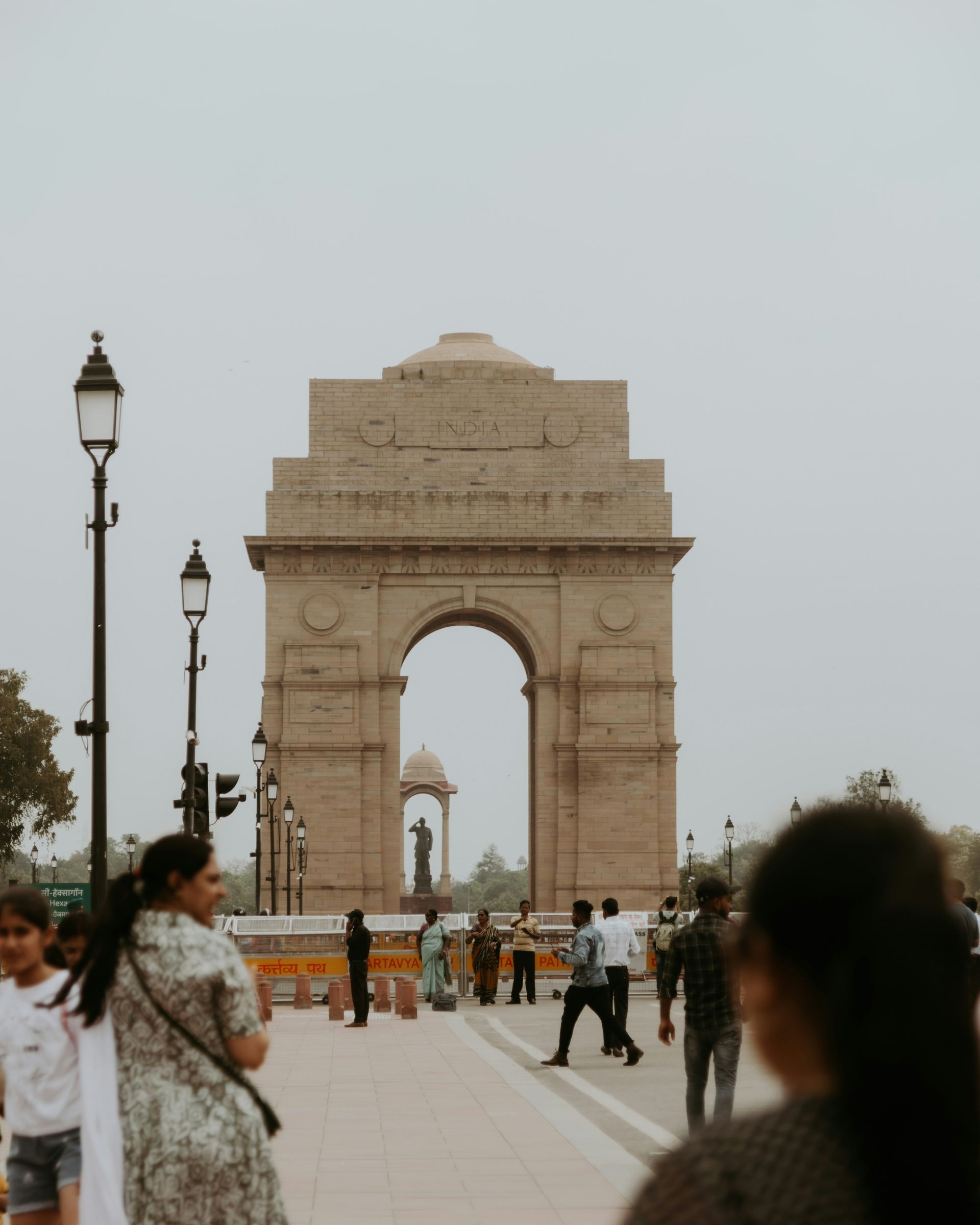 India Gate in Delhi, a war memorial arch, with people walking in front.