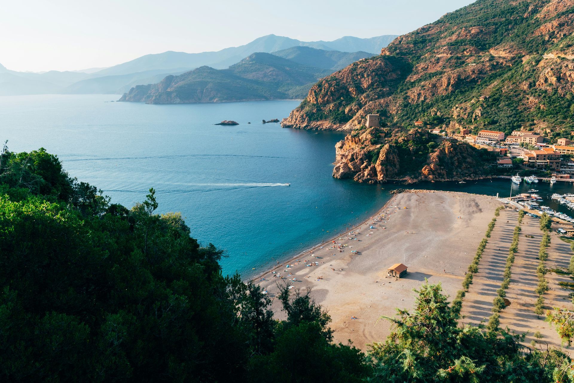 There is a beach in the middle of the ocean surrounded by mountains in Corsica, France.