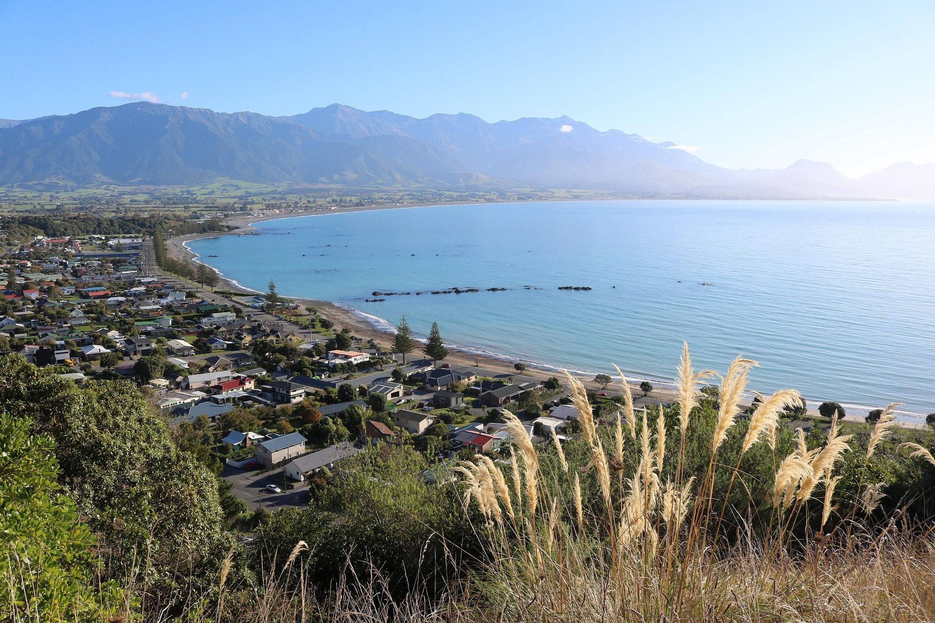A view of Kaikōura, New Zealand on the ocean with mountains in the background.