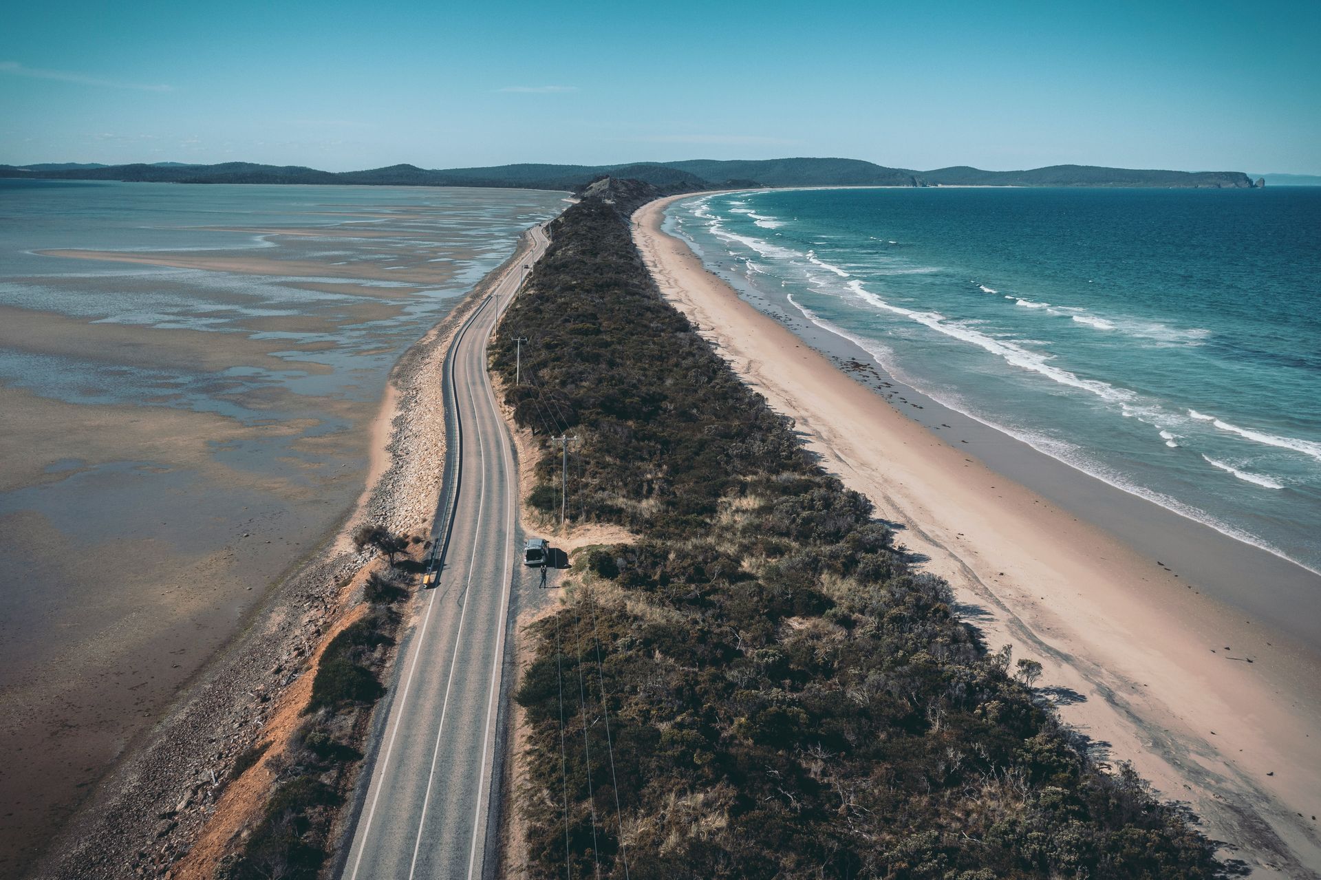 An aerial view of a road leading to the ocean in Tasmania, Australia.