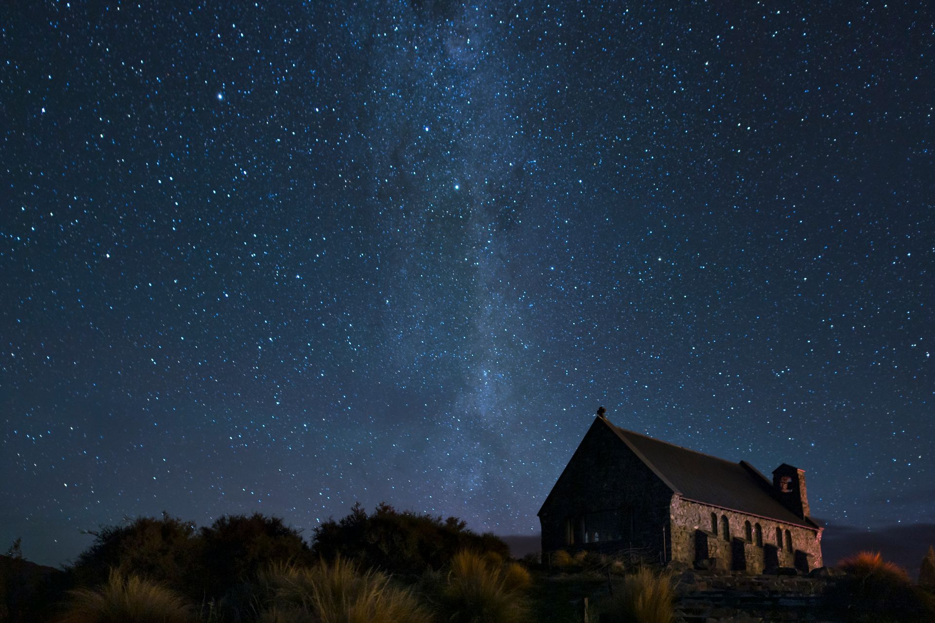 A church is silhouetted against a starry night sky on Lake Tekapo, New Zealand.