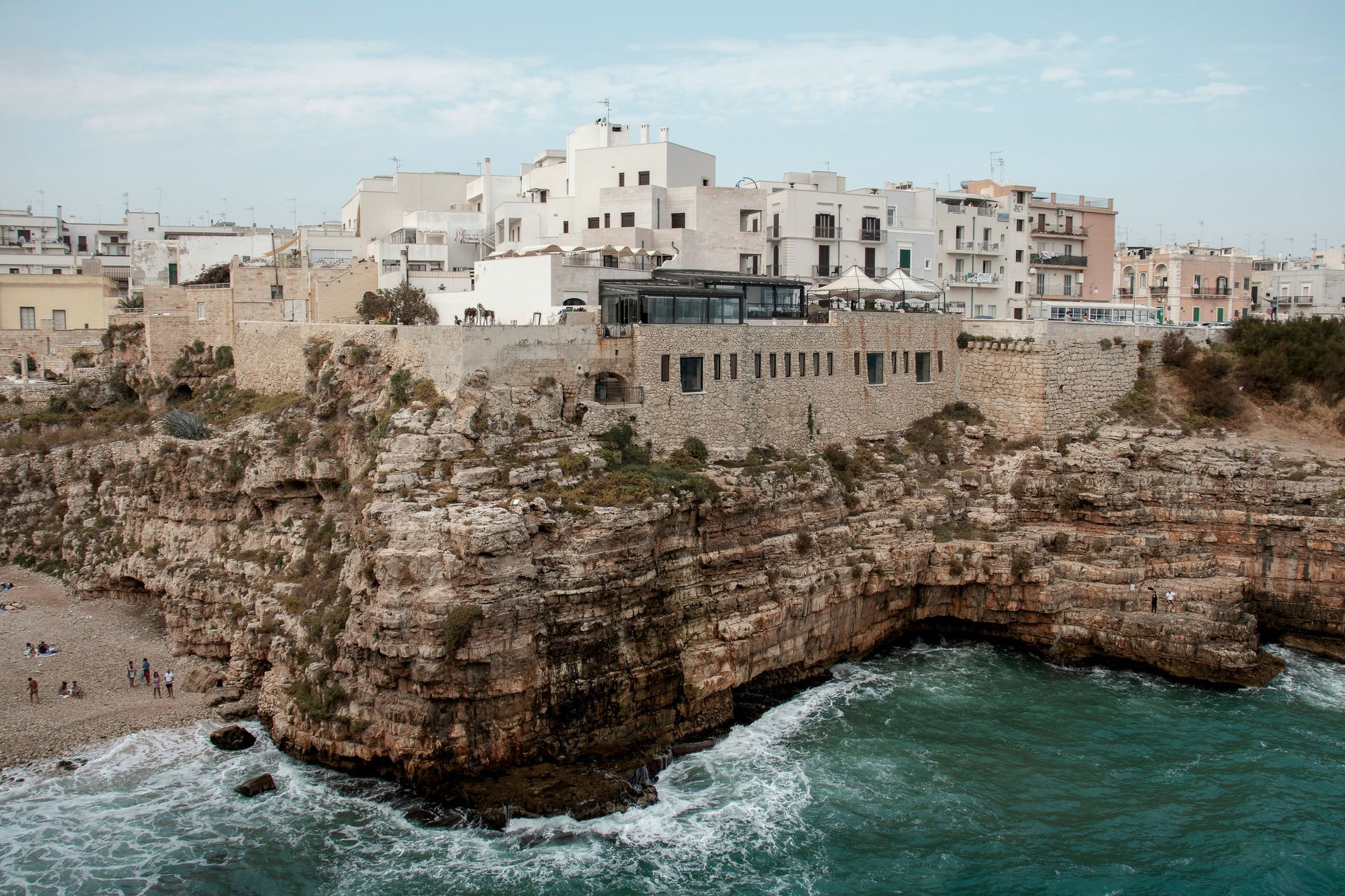 A city sitting on top of a cliff overlooking the ocean in Polignano a Mare, Italy.