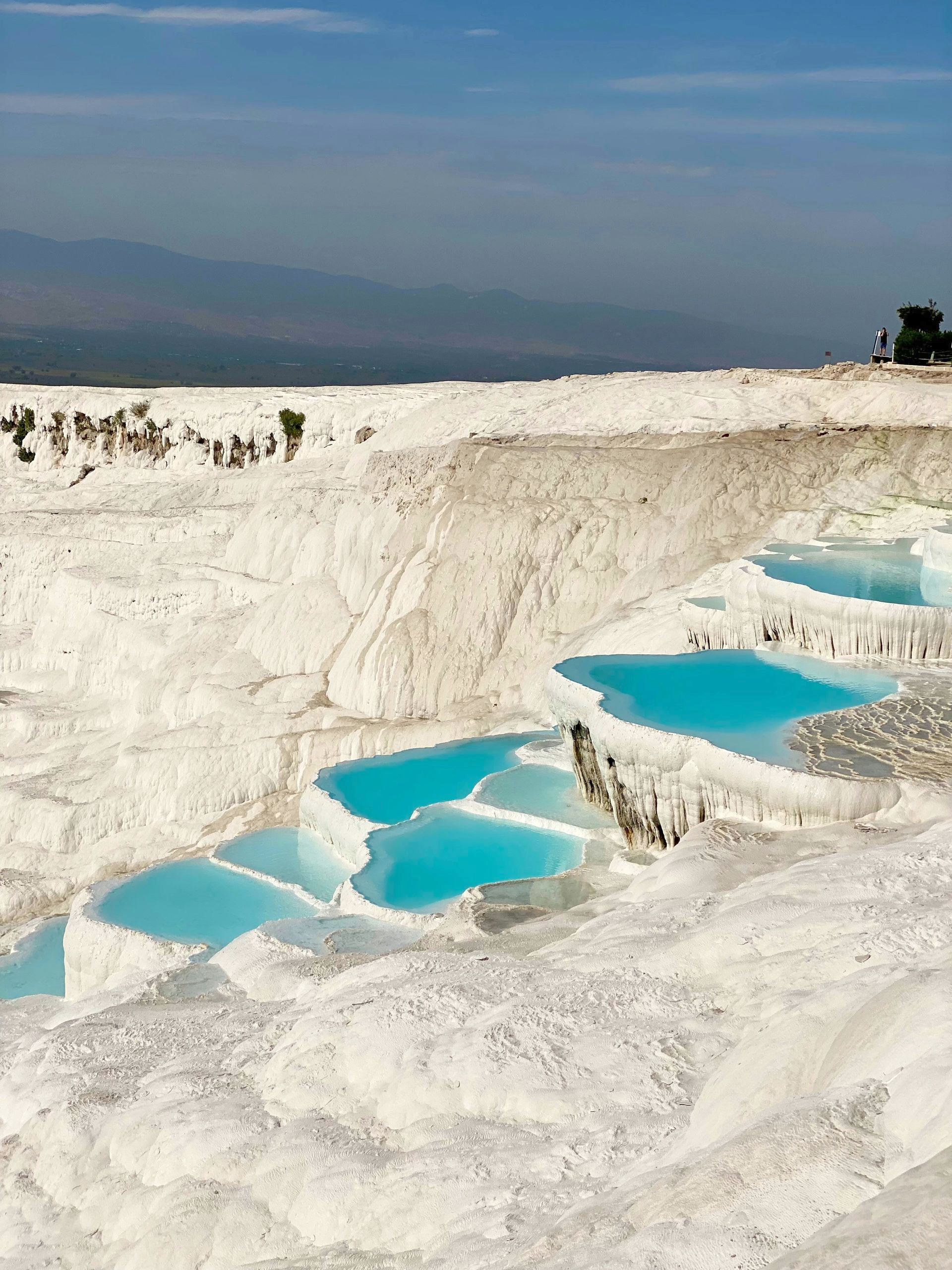 Travertine terraces with bright turquoise water cascading down in Pamukkale, Turkey.