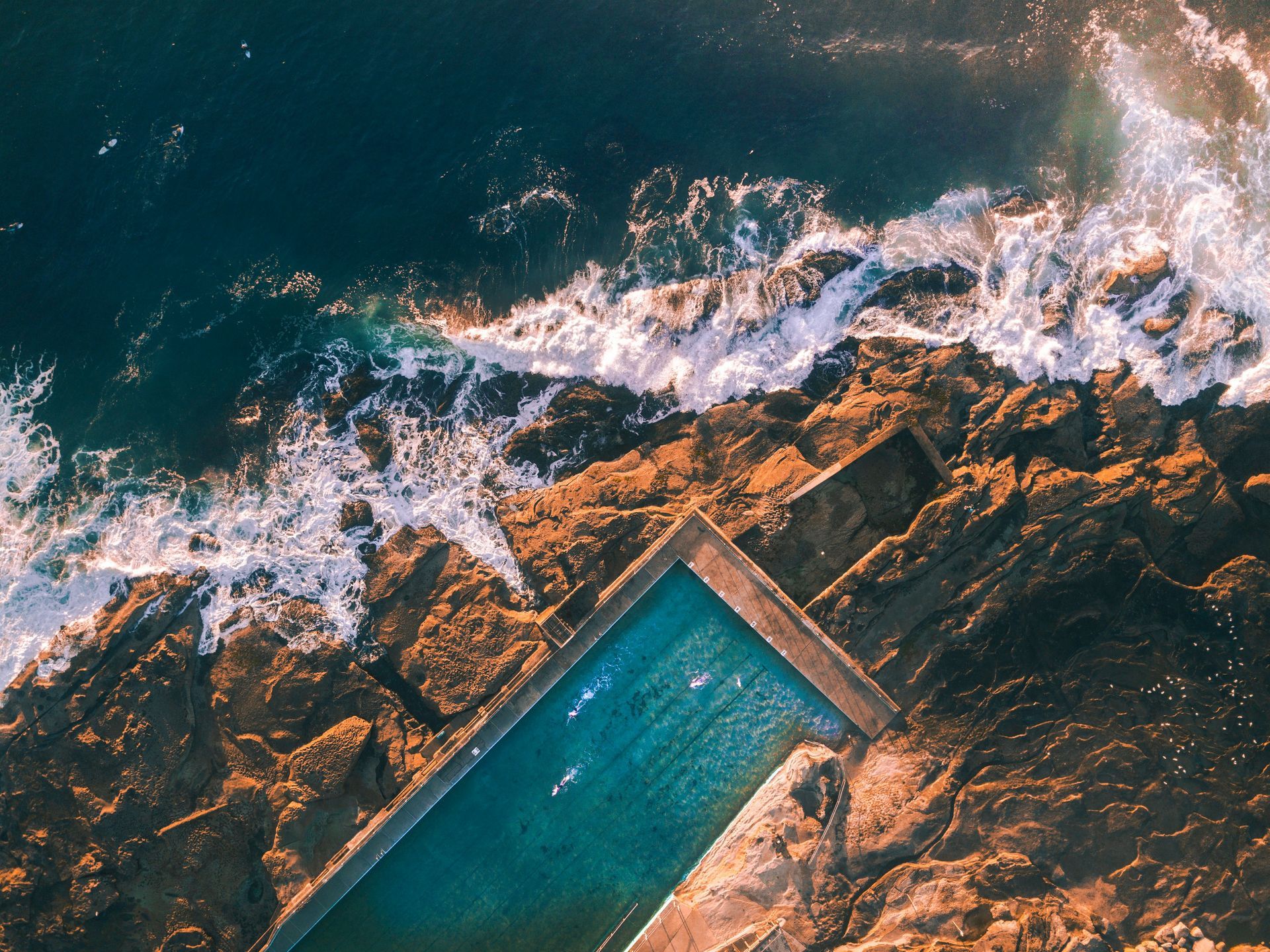 An aerial view of Bondi Icebergs Pool
surrounded by rocks on the ocean in Australia.