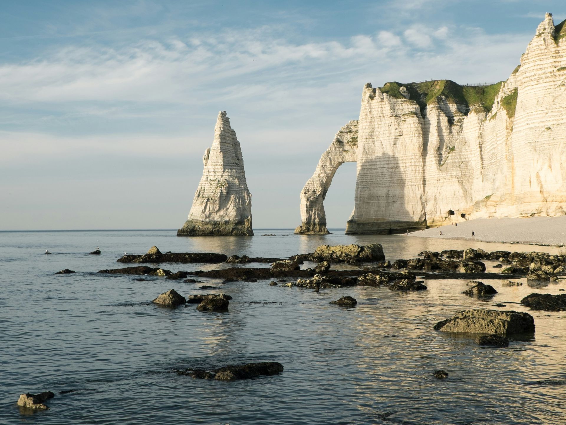 A large rock formation in the middle of the ocean at Étretat beach in Normandy, France.