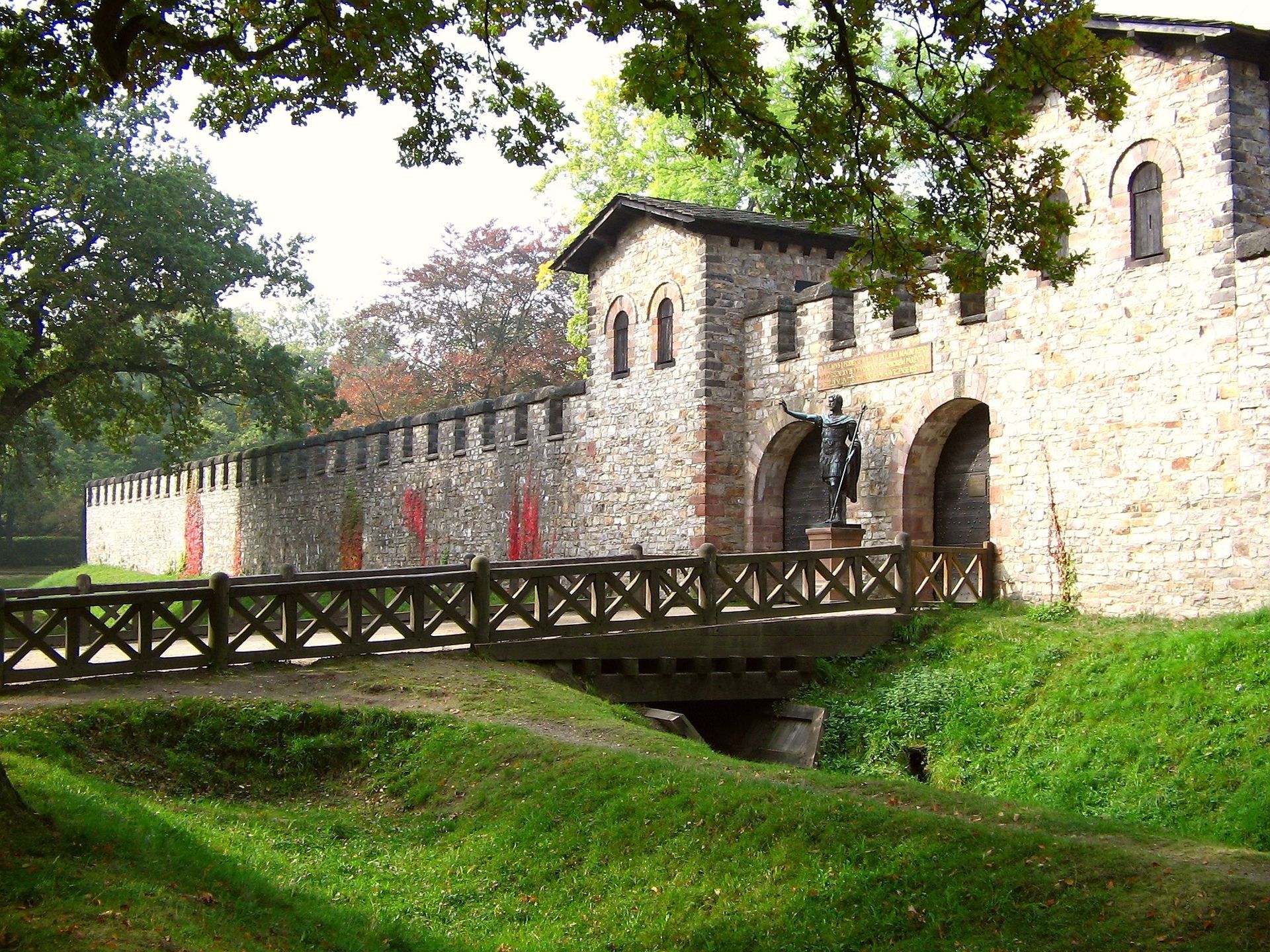 A stone building with a wooden bridge in front of it in Saalburg, Germany.