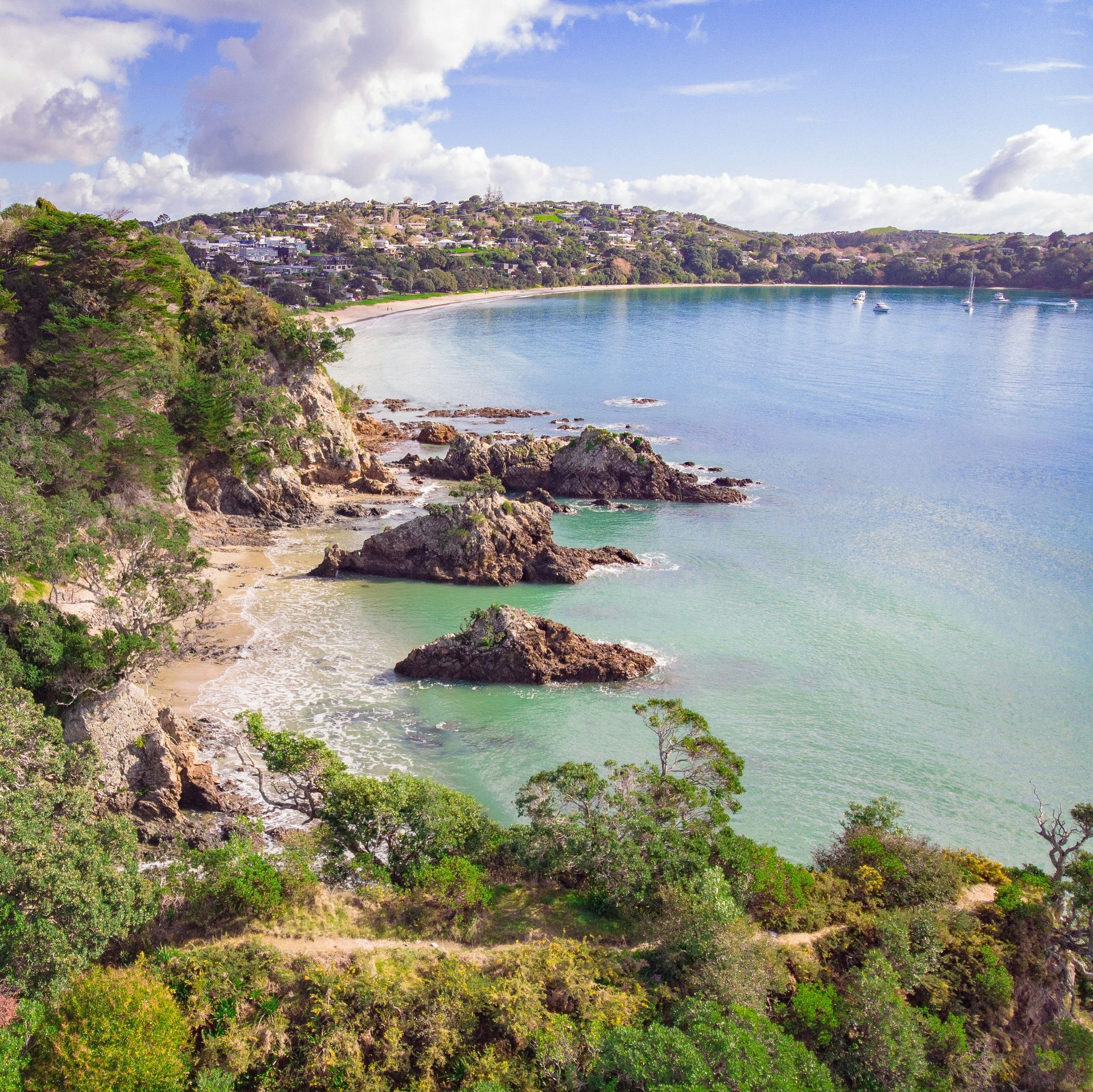 An aerial view of a large body of water surrounded by trees on Waiheke Island, New Zealand.