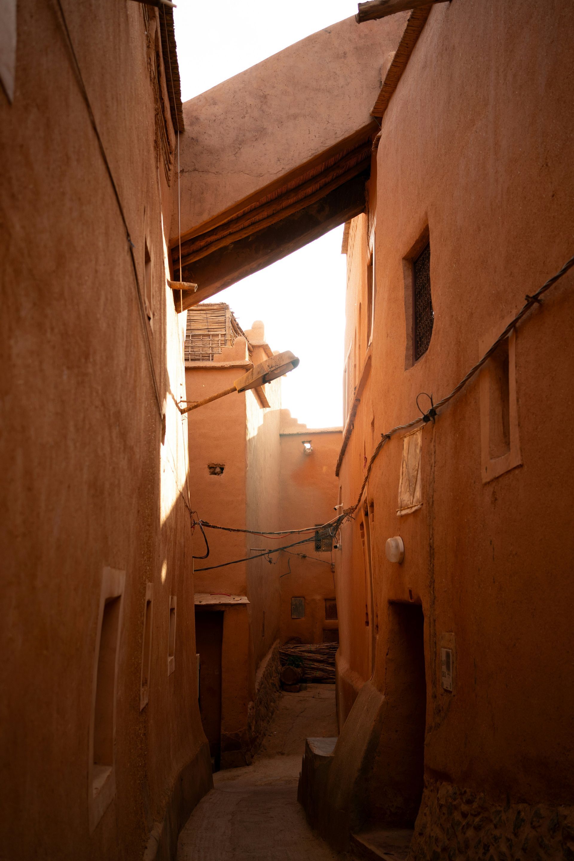 A narrow alleyway between two brown buildings in Ouarzazate, Morocco.