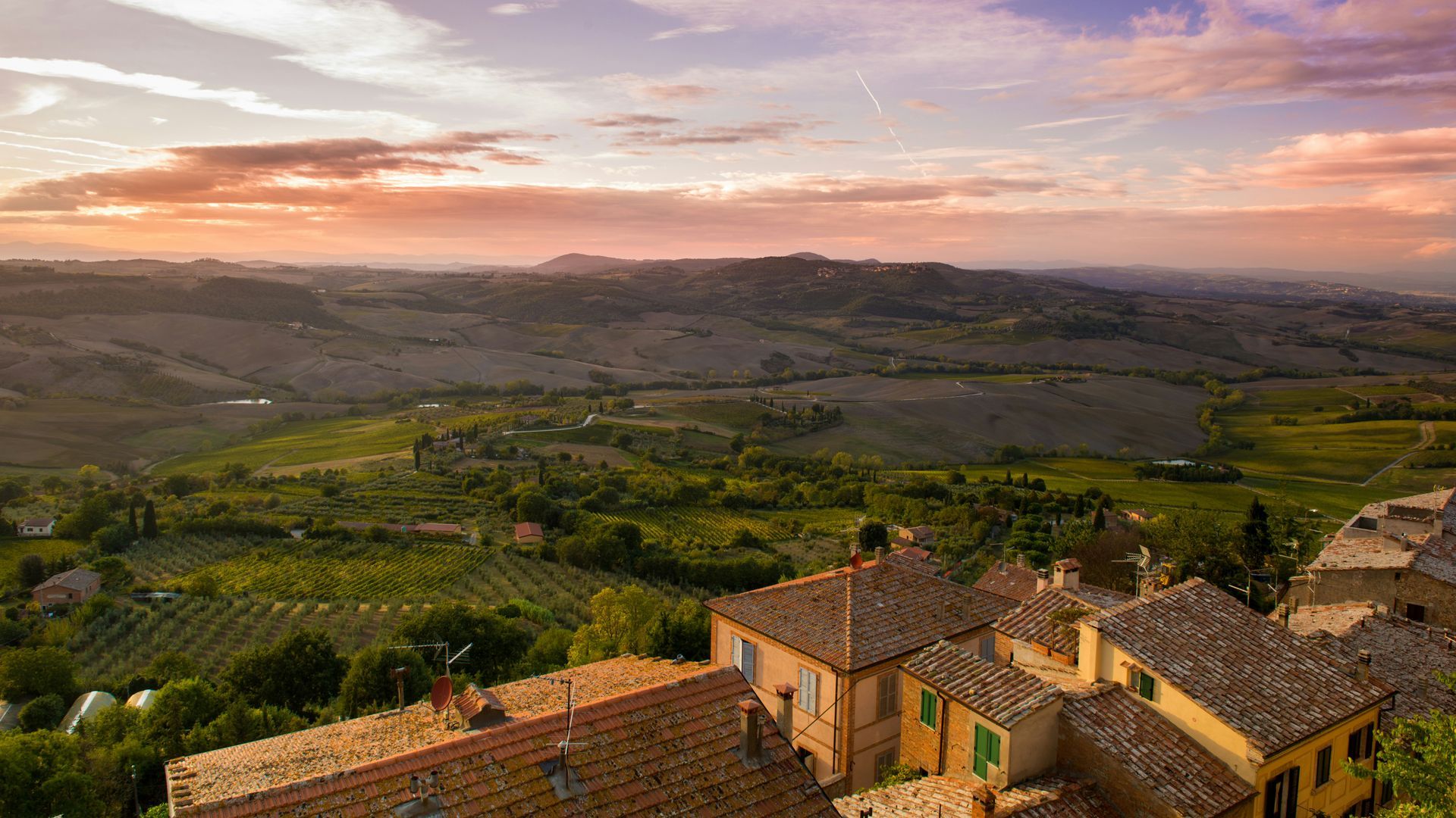 An aerial view of a village in the countryside at sunset in Asciano, Tuscany.