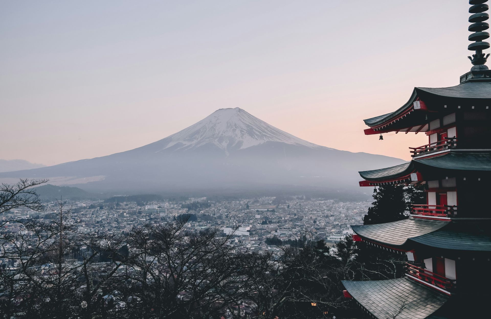 A pagoda with Mount Fuji in the background and a city in the foreground.