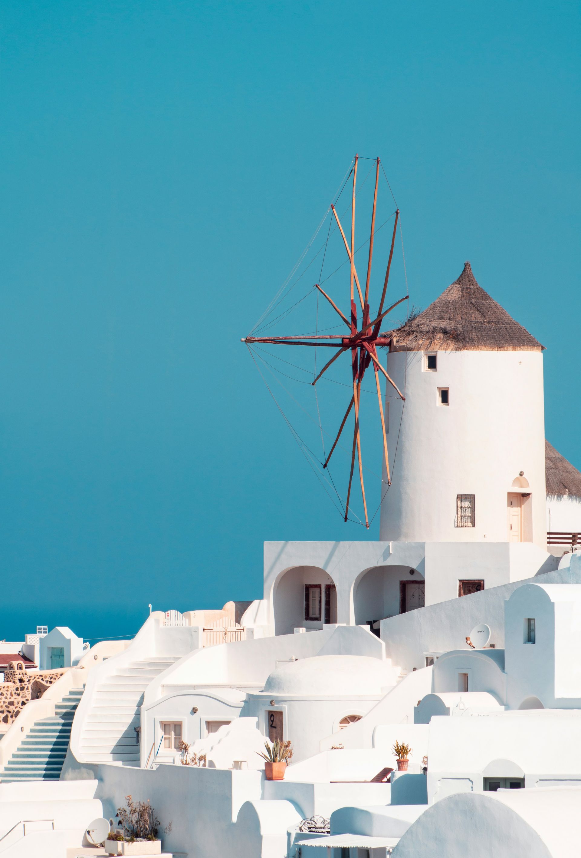 There is a windmill in the middle of a white village in Mykonos, Greece.