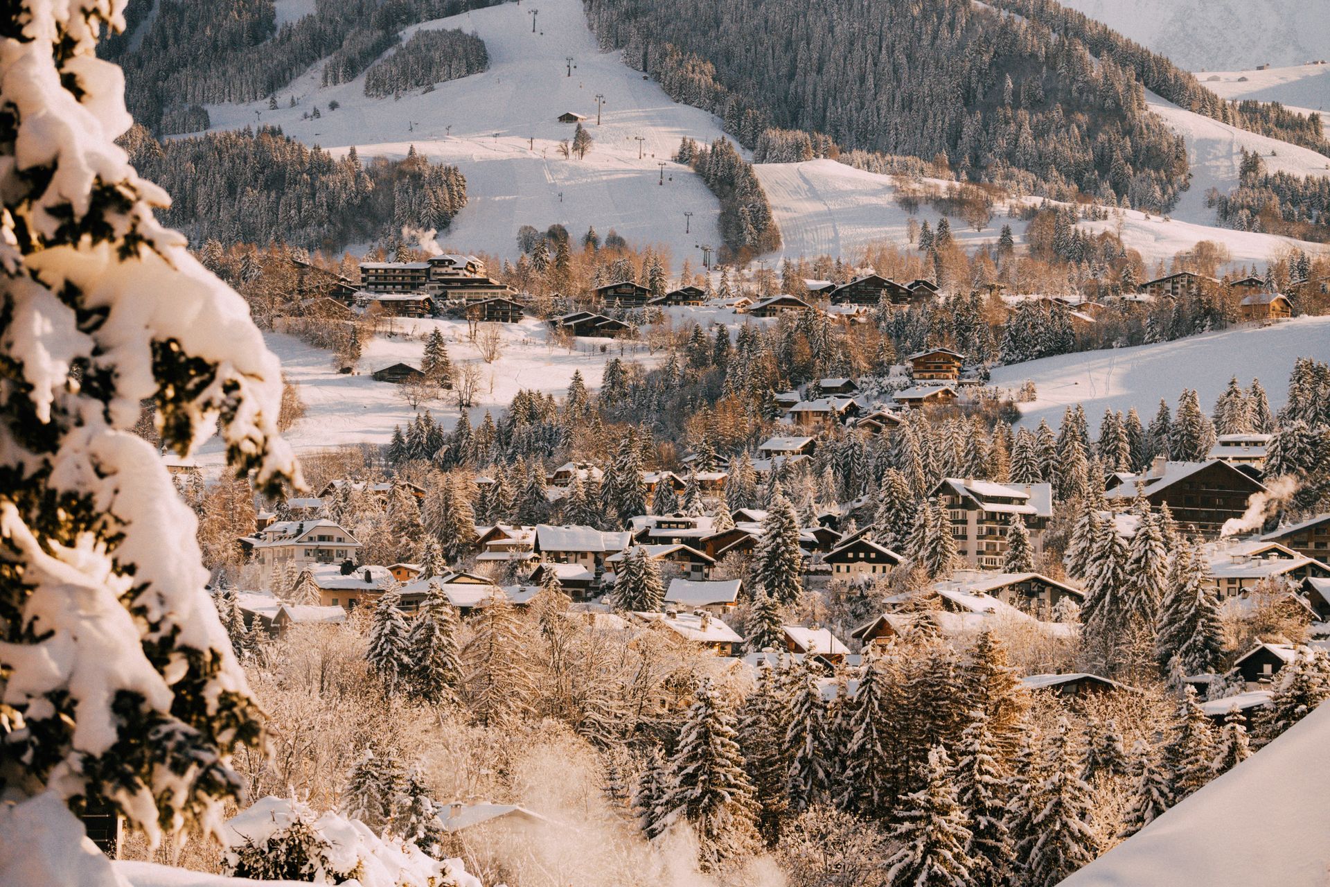 A snowy landscape with a ski resort in the background in Megève, France.