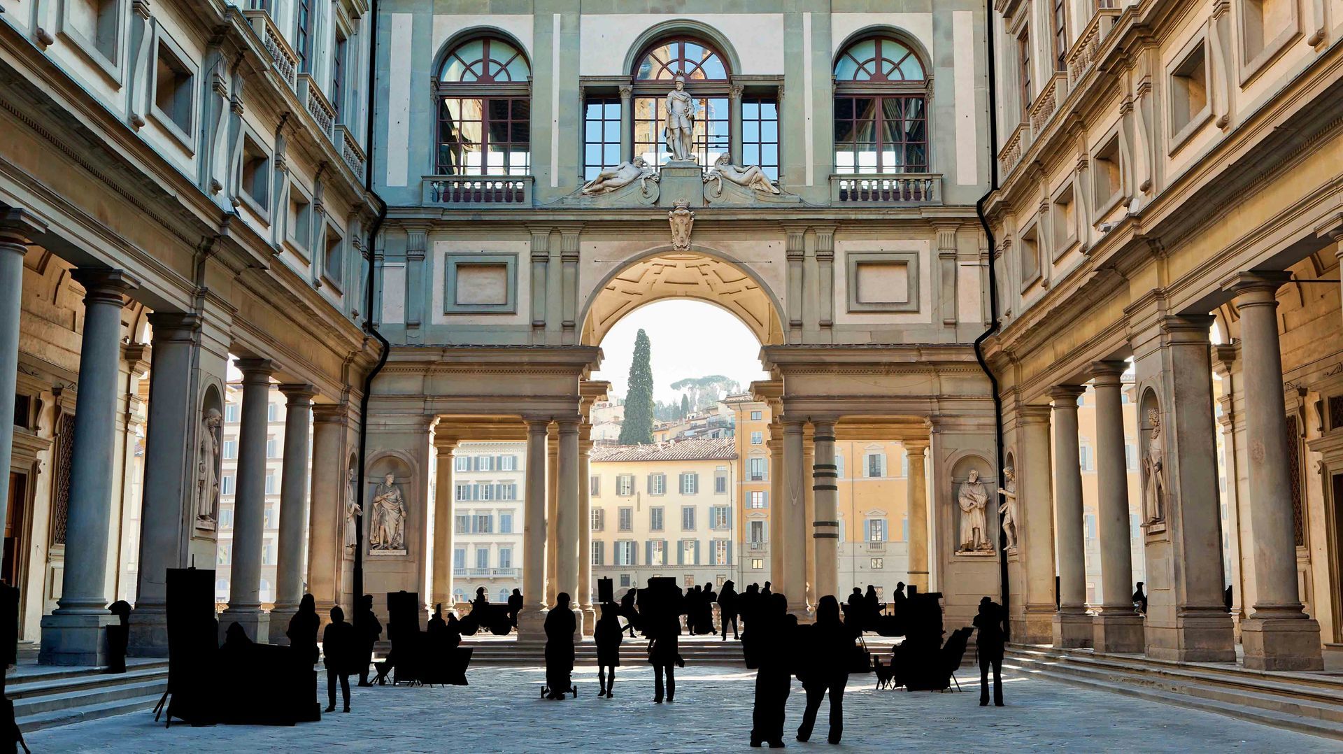 A group of people are standing in front of a large building in Florence.