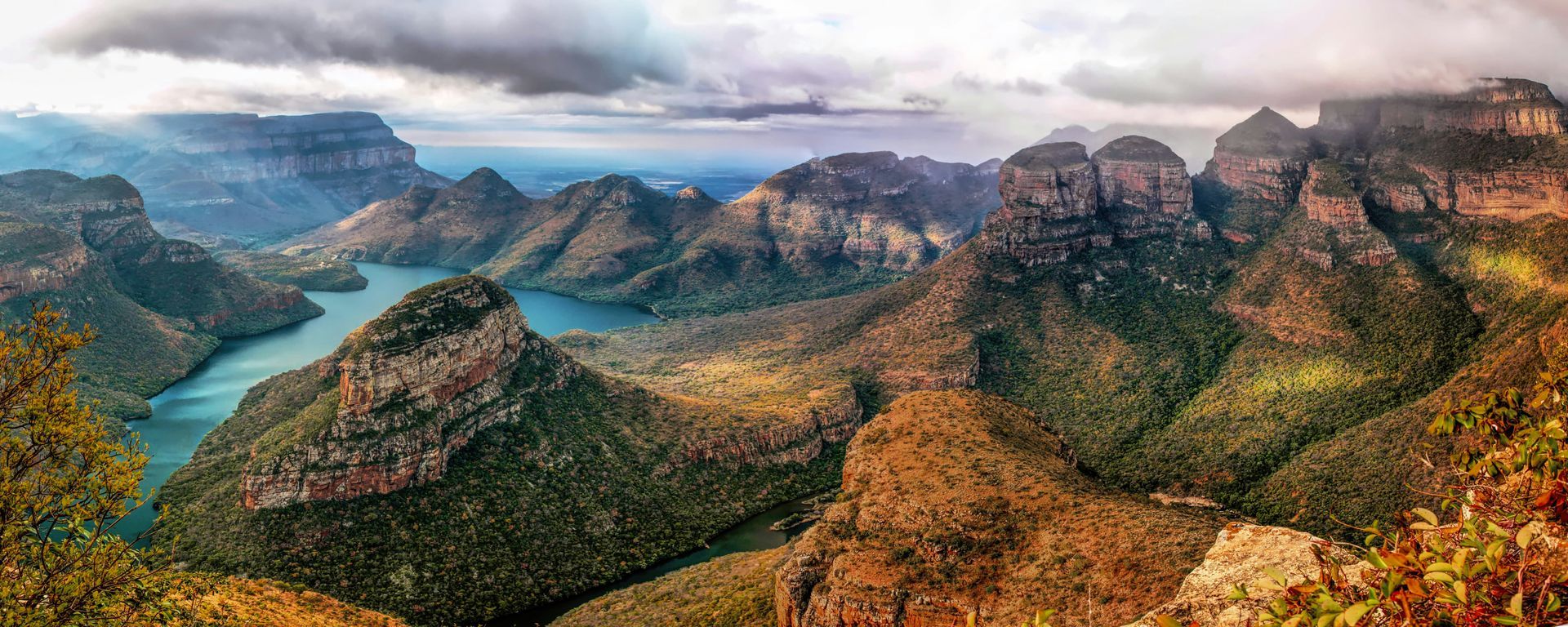 A panoramic view of Blyde River Canyon with mountains and a river in South Africa.