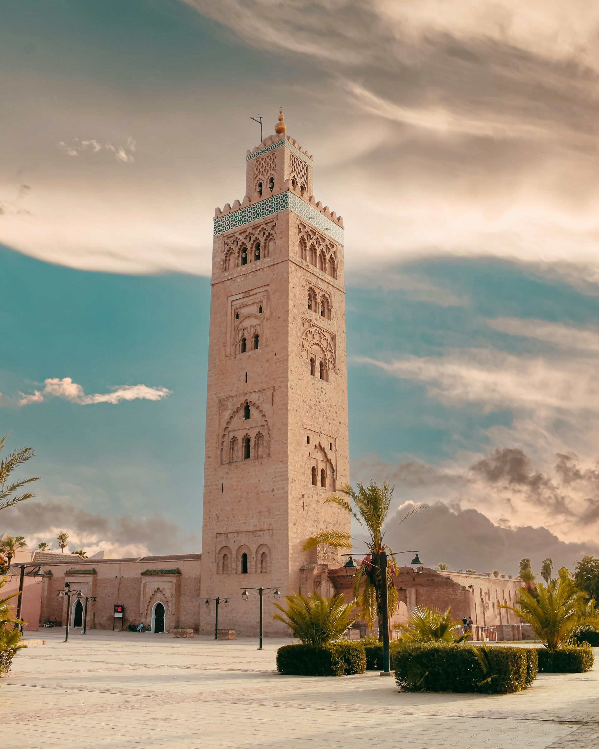 A very tall building with a clock tower on top of it in Marrakesh, Morocco.