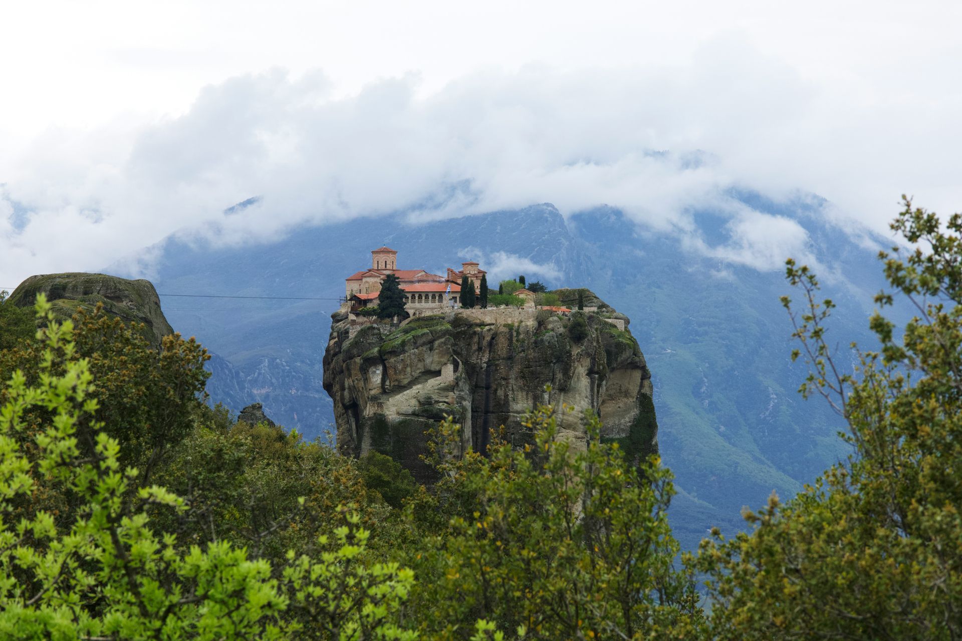 The Meteora Monastery is sitting on top of a rock in the middle of a mountain in Kalabaka, Greece.