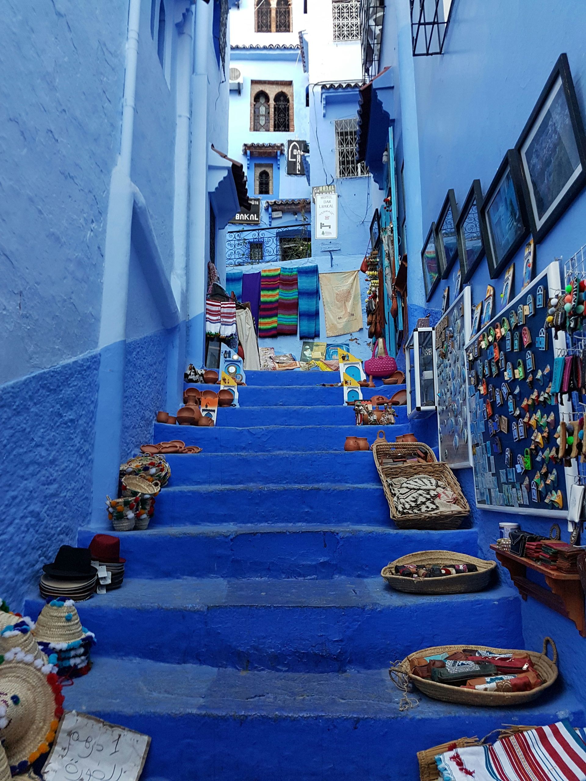 A set of blue stairs leading up to a store in Chefchaouen, Morocco.