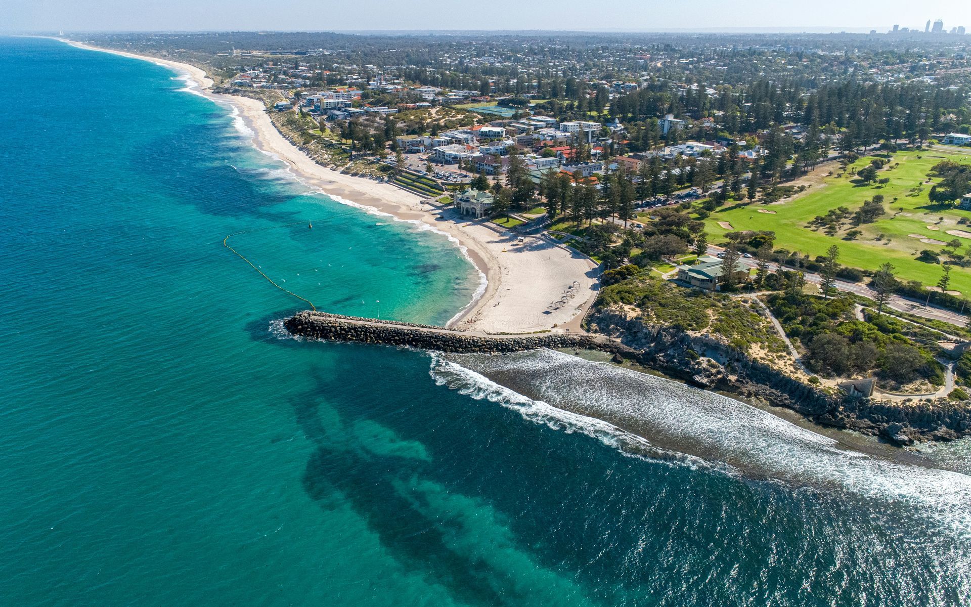 An aerial view of a beach with a golf course in the background in Western Australia.