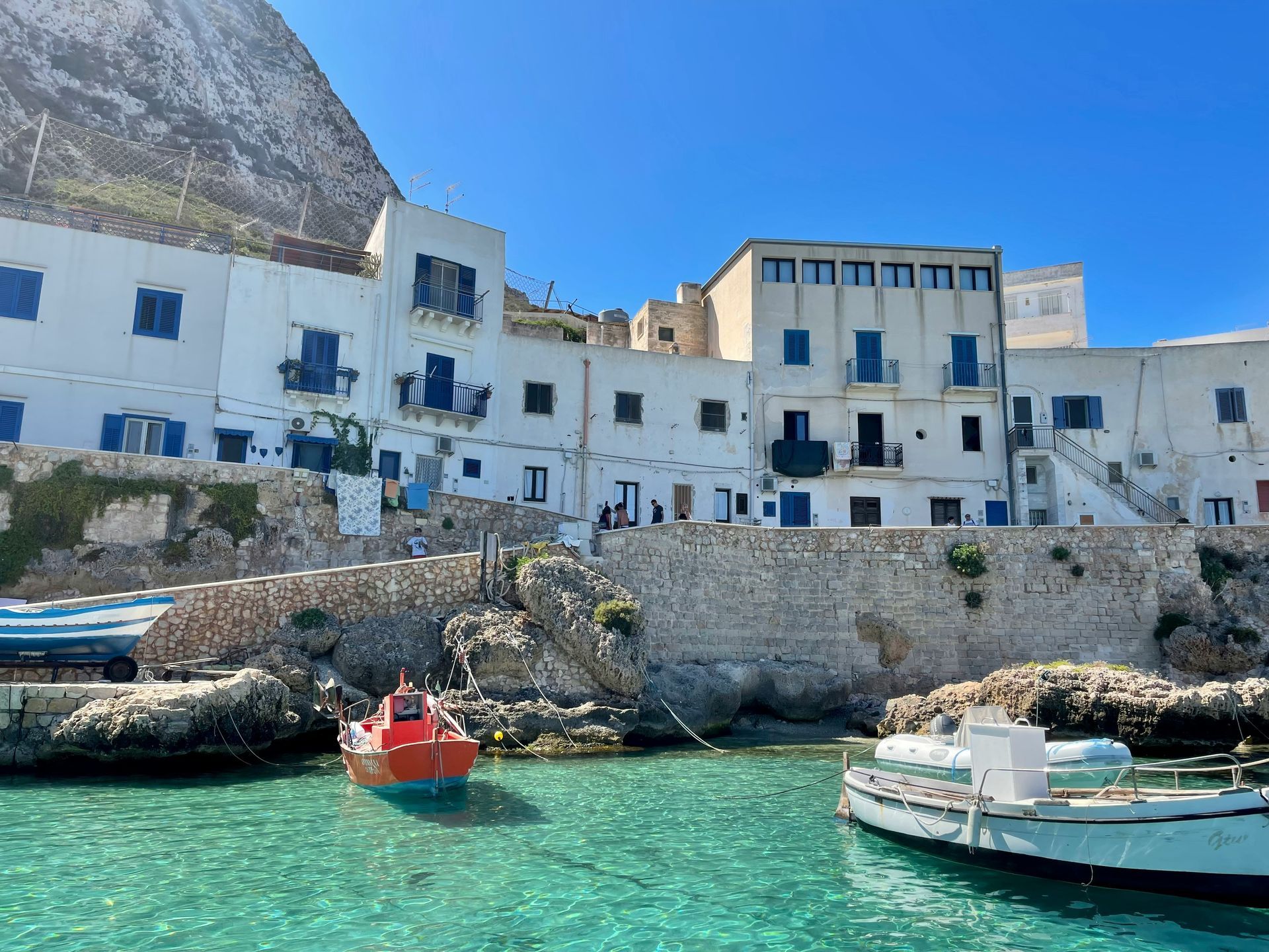 A boat is docked in front of a building in the water in Sicily.