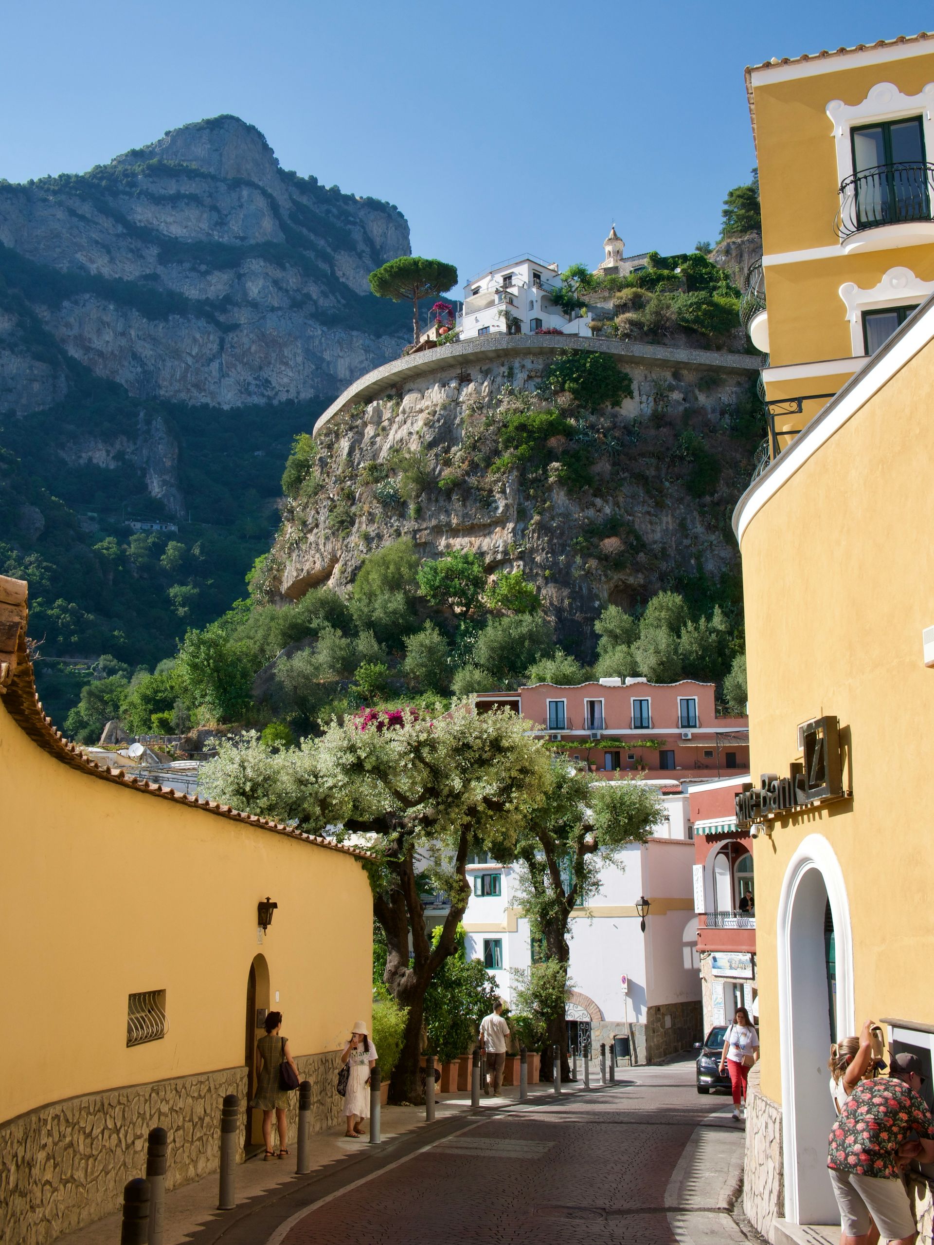 A yellow building with a mountain in the background on the Amalfi Coast.