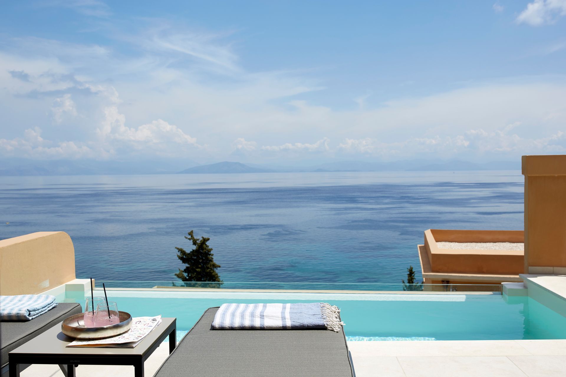 There is a swimming pool with a view of the ocean at Nido Hotel, Mar-Bella Collection in Corfu, Greece.