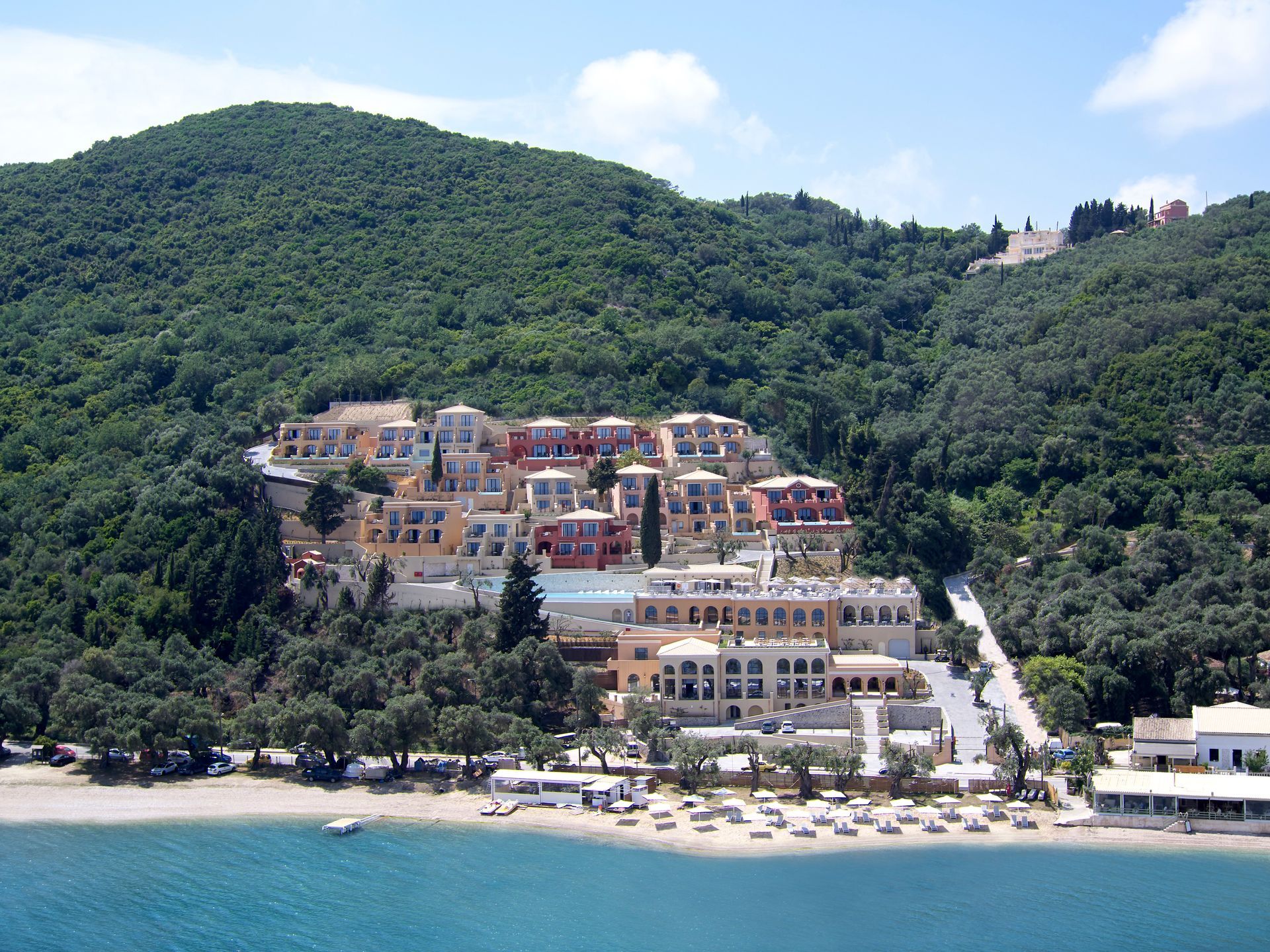 An aerial view of Nido Hotel, Mar-Bella Collection surrounded by mountains and trees in Corfu, Greece.