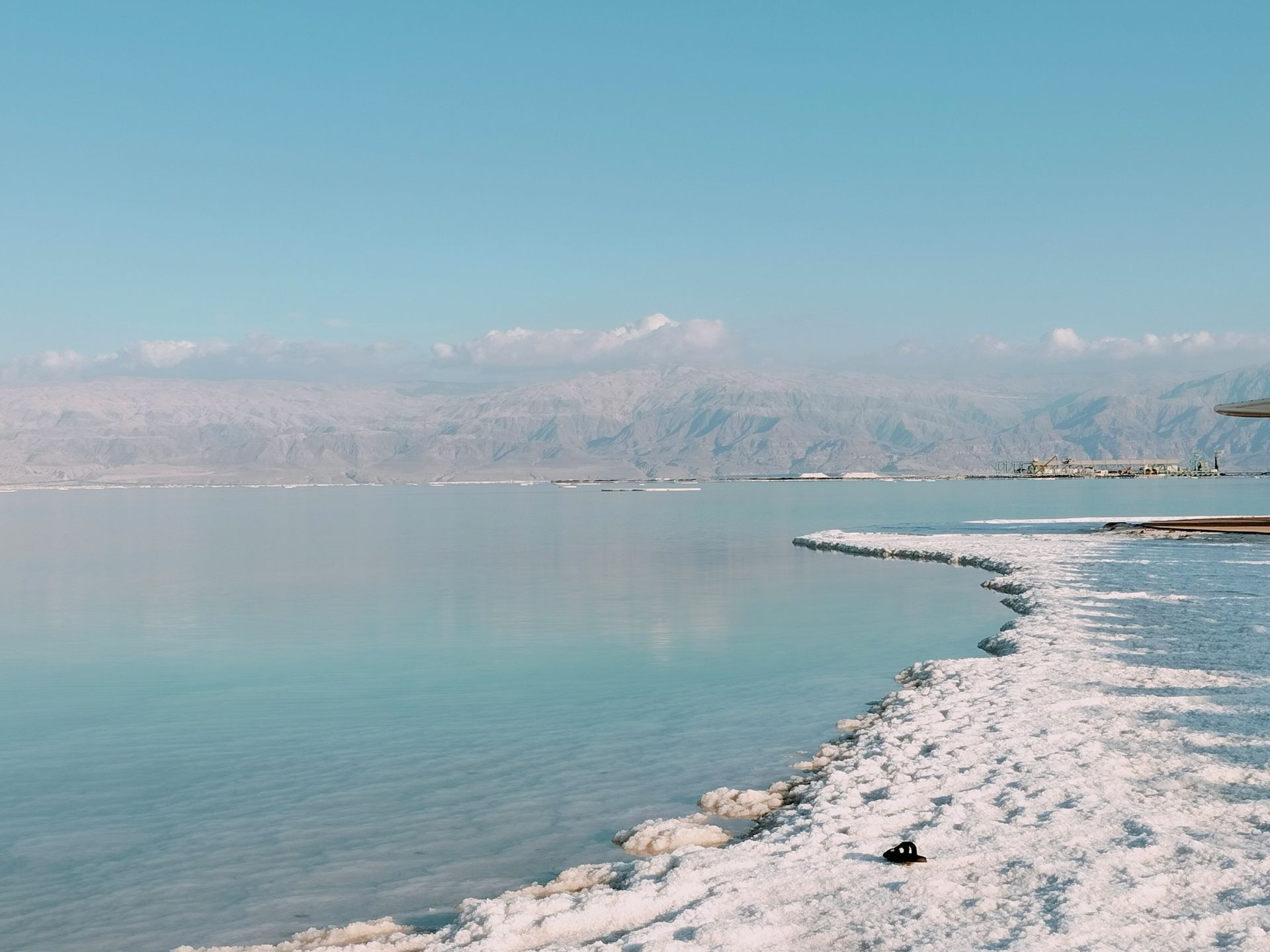 Dead Sea shoreline with salt formations, turquoise water in Jordan.