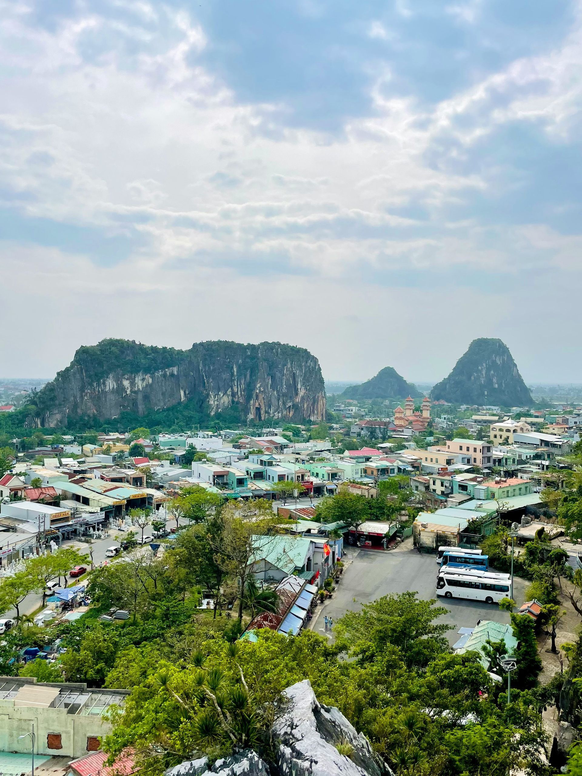 View of a town with mountains in the background, cloudy sky above, in Da Nang, Vietnam.