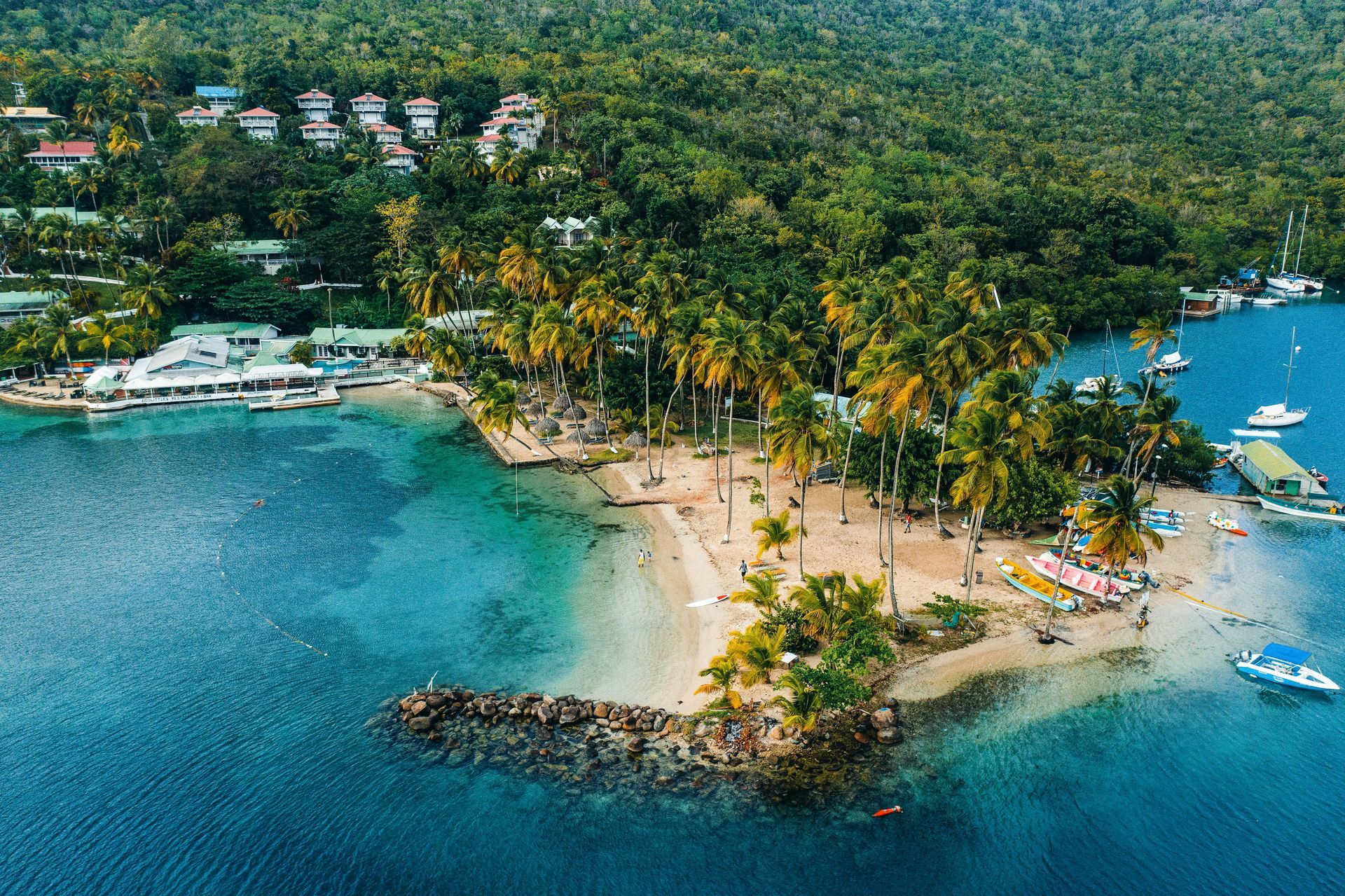 An aerial view of a small island in the middle of a body of water surrounded by trees.