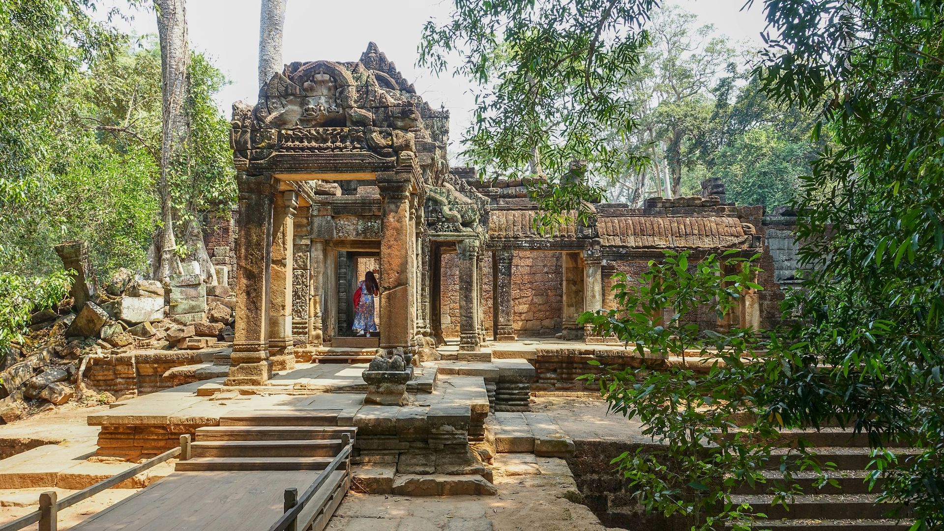 Stone temple ruins in a lush green forest in Siem Reap, Cambodia.