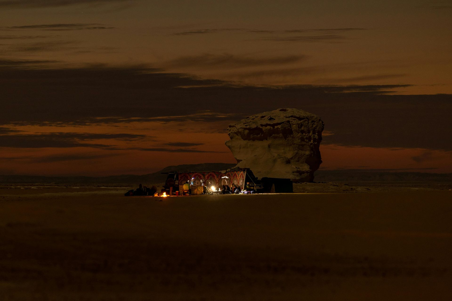 A large rock in the middle of a desert at night in Siwa, Egypt.