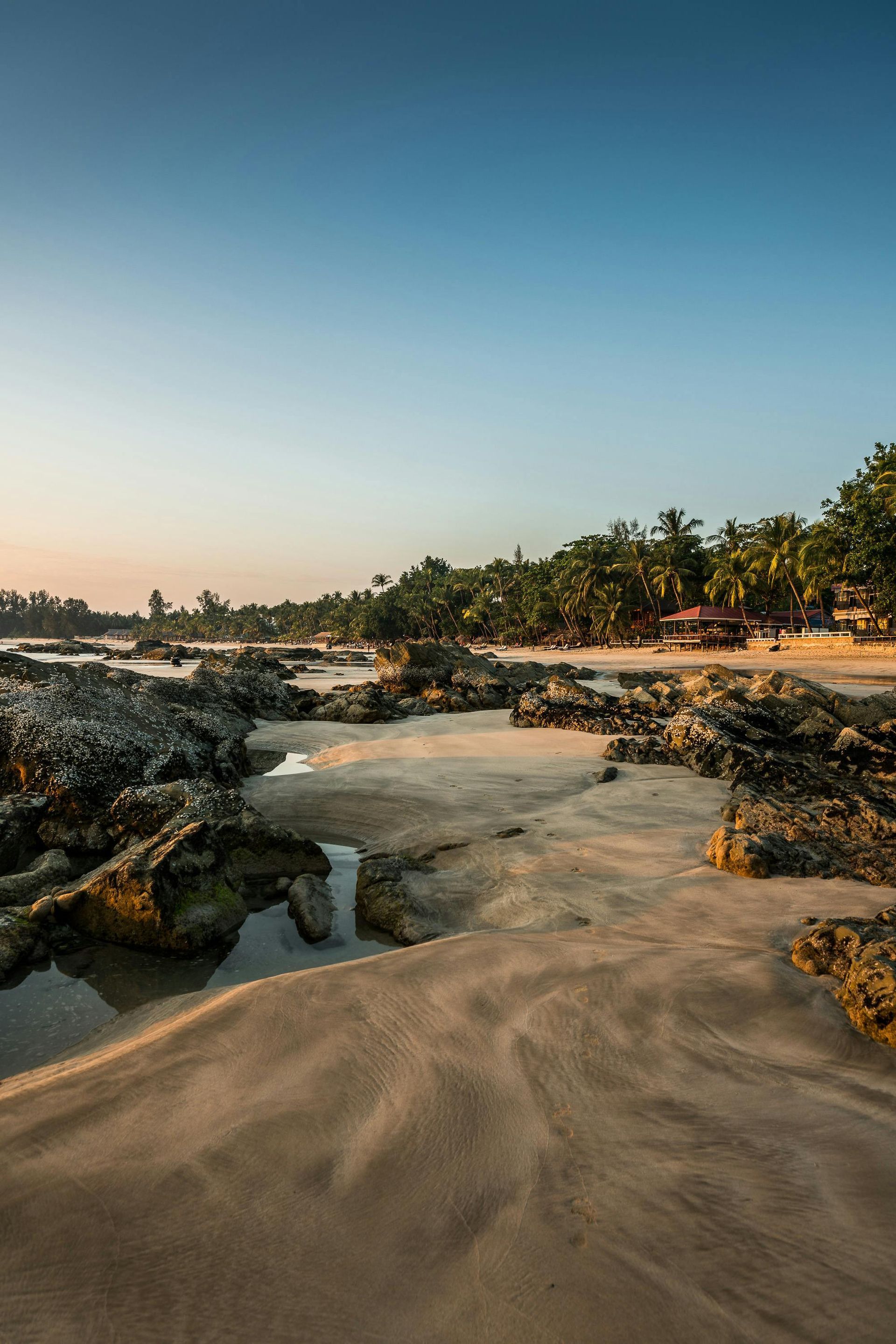 There is a stream running through the sand on the beach in Thailand.