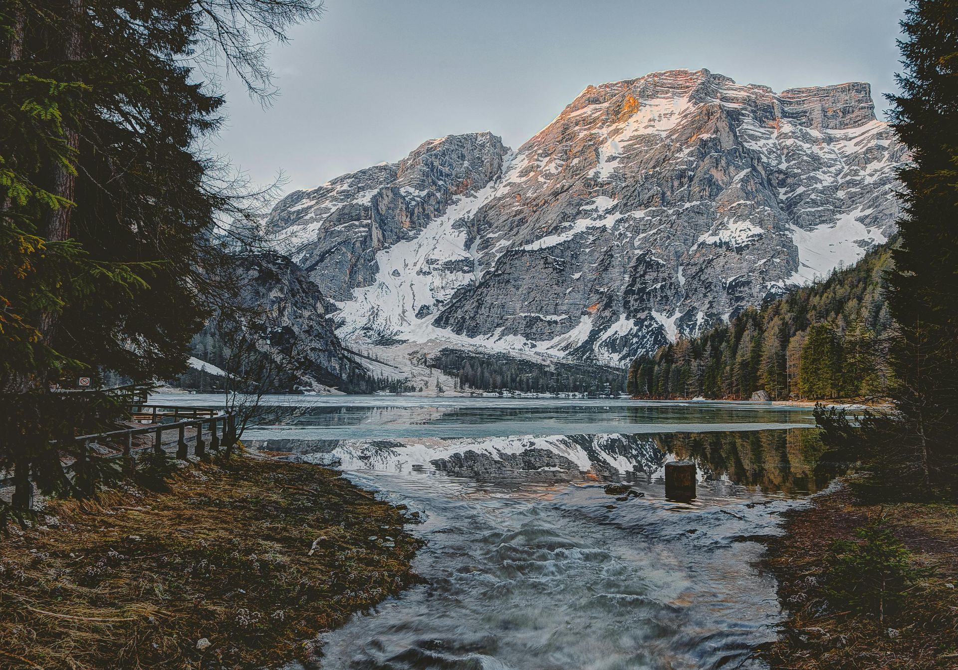 A lake surrounded by snow-covered mountains and trees in the Alps of Switzerland. 