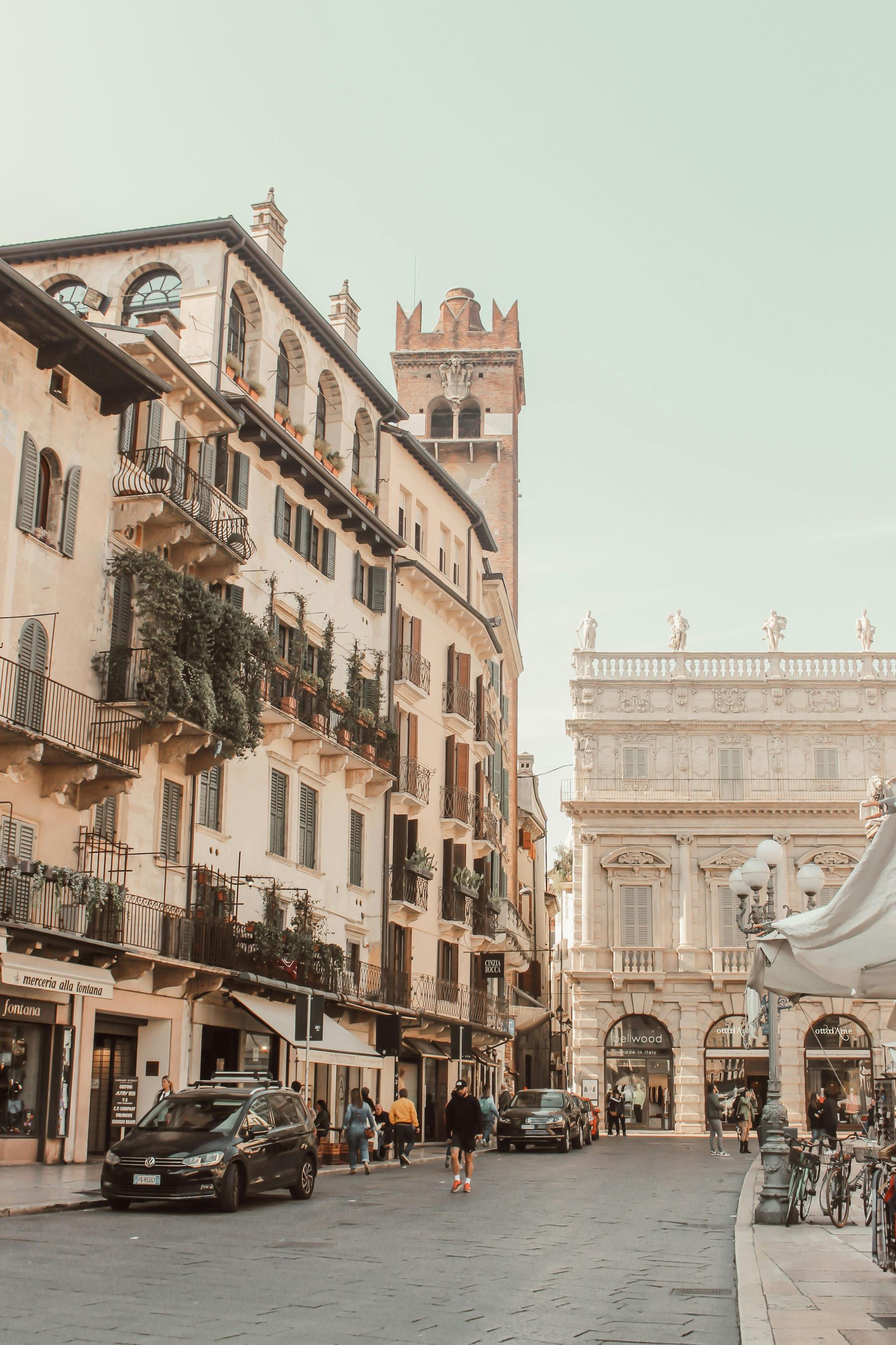 A city street with a lot of buildings and cars parked on the side of the road in Verona, Italy.