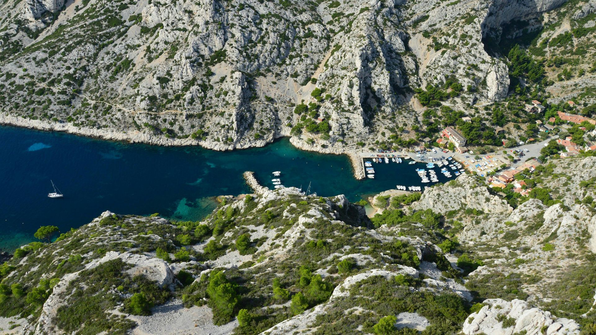 An aerial view of the Calanques surrounded by mountains and trees in southern France. 