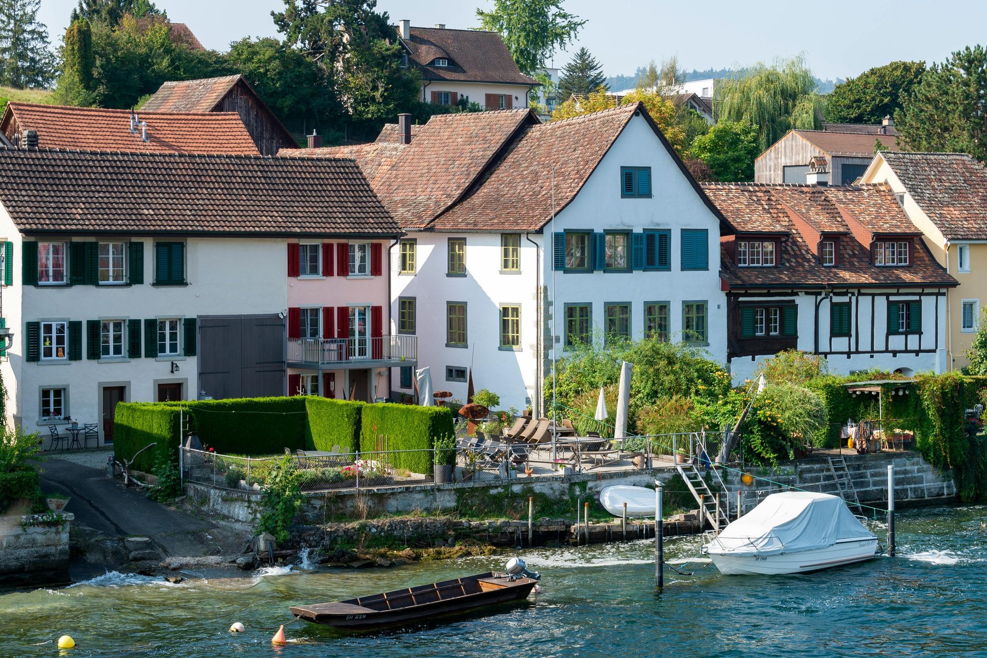 A boat is docked in front of a row of houses on the The Rhine River.