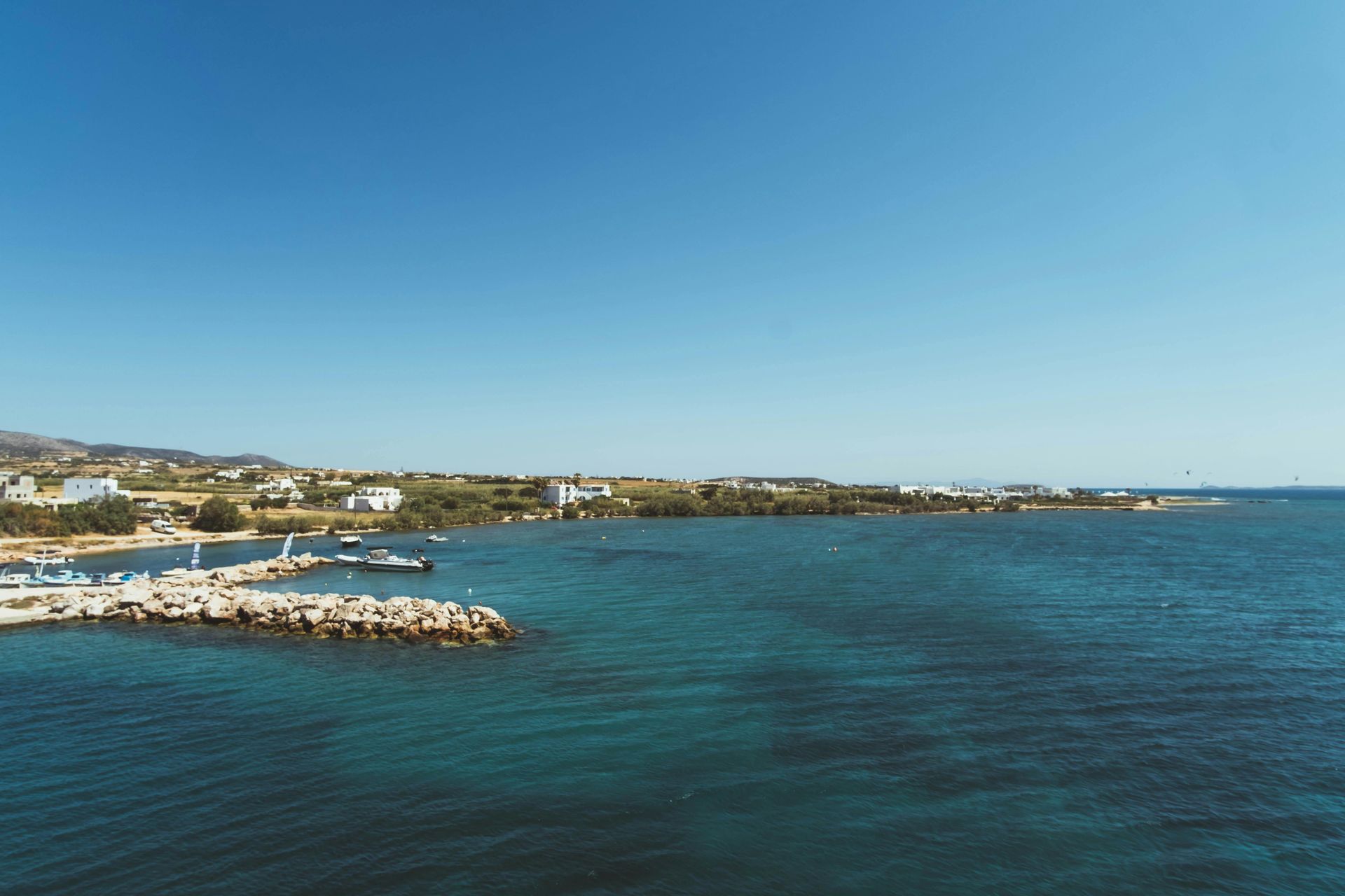 A large body of water with a small island in the middle of it in Paros, Greece.