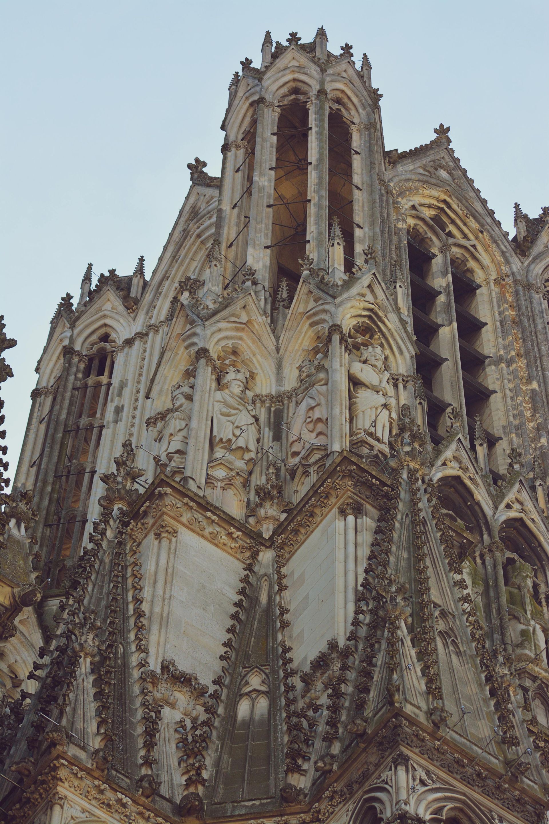 A very tall building with a lot of statues on it in Champagne, France.