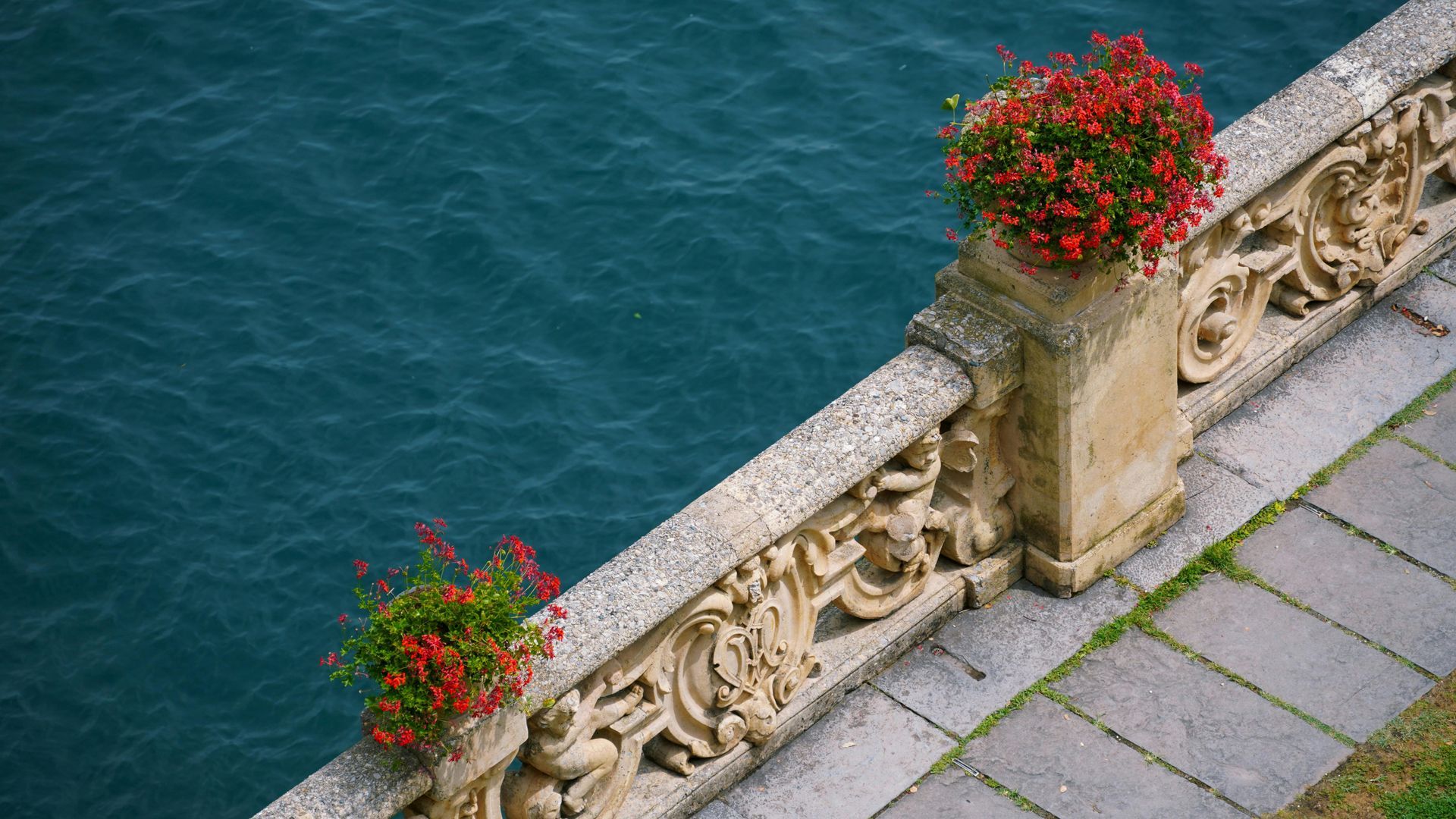 A stone fence with flowers on it on Lake Garda, Italy.