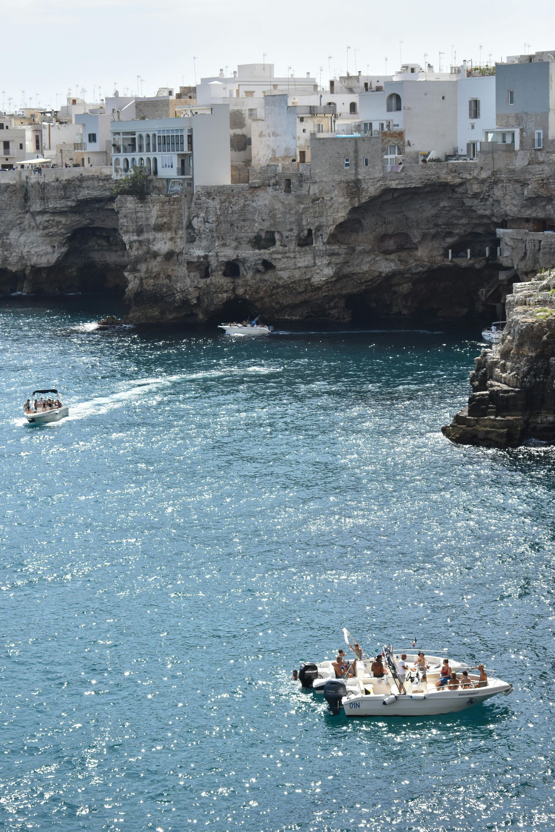 A group of people are riding a boat in the ocean in Puglia, Italy.