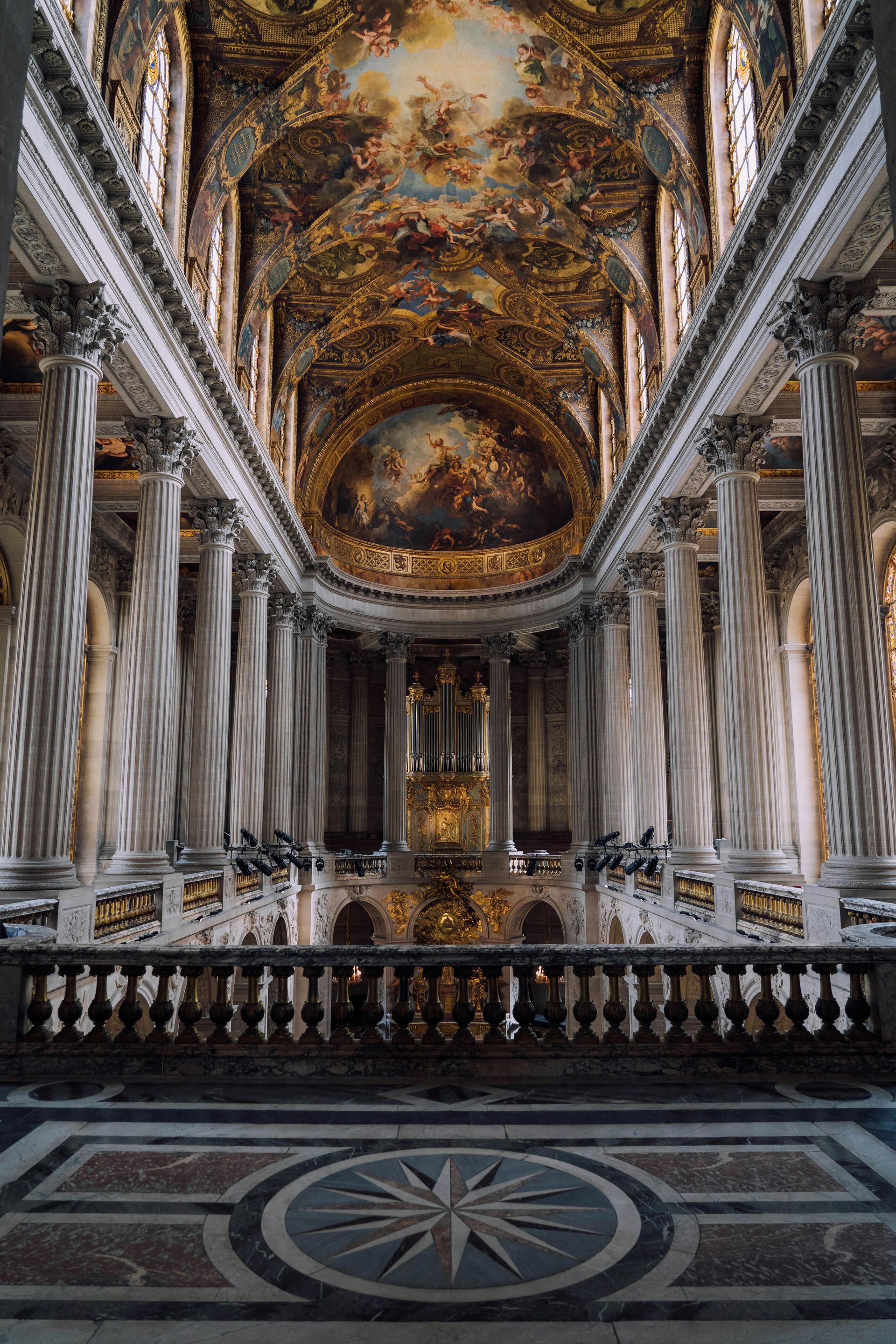 The inside of a church with columns and a balcony in northern france. 