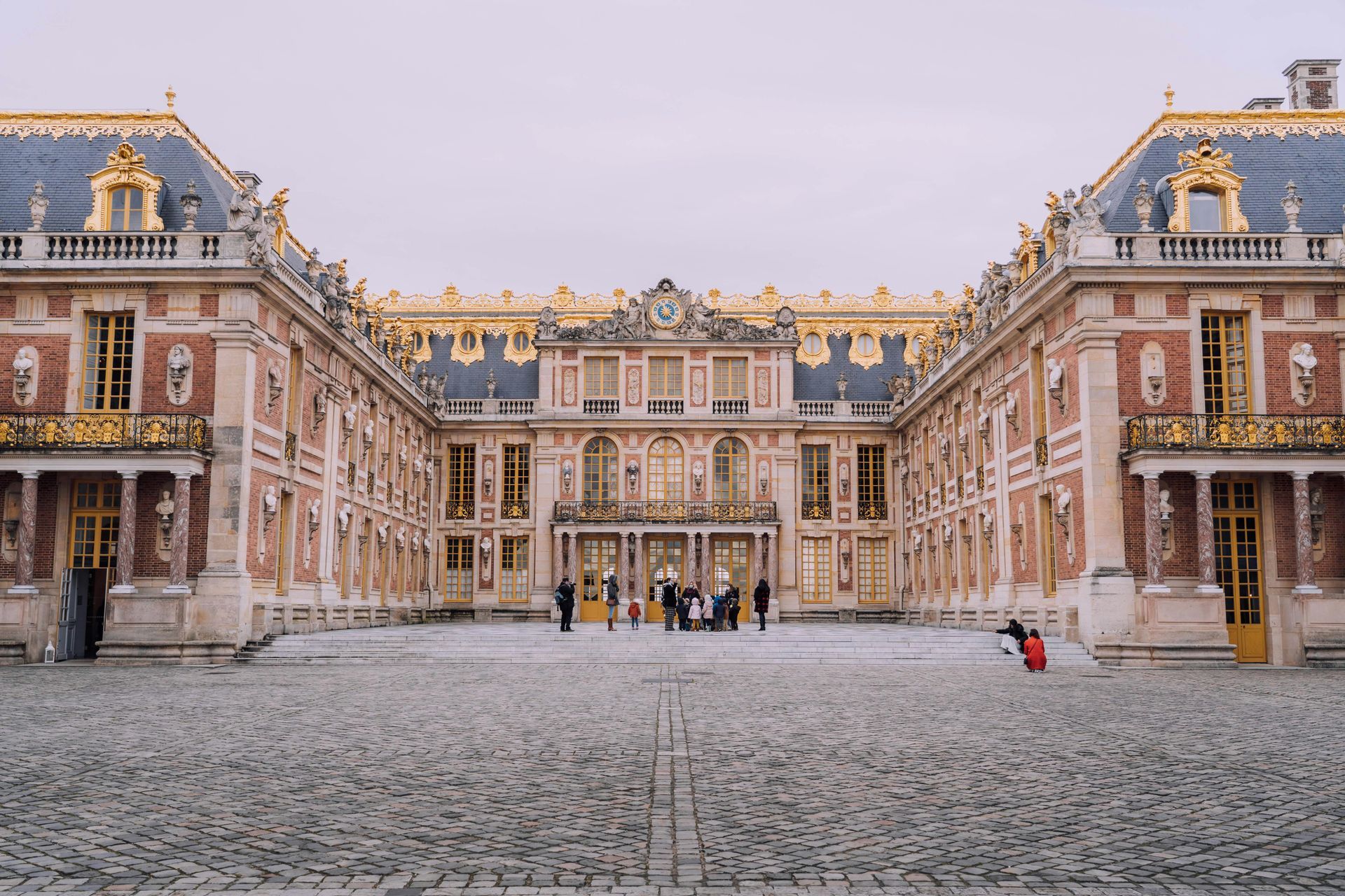 A group of people are standing in front of a large building in northern france.