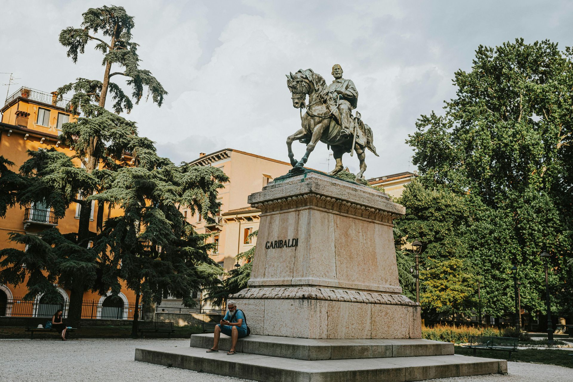 A statue of a man riding a horse in a park in Verona, Italy.