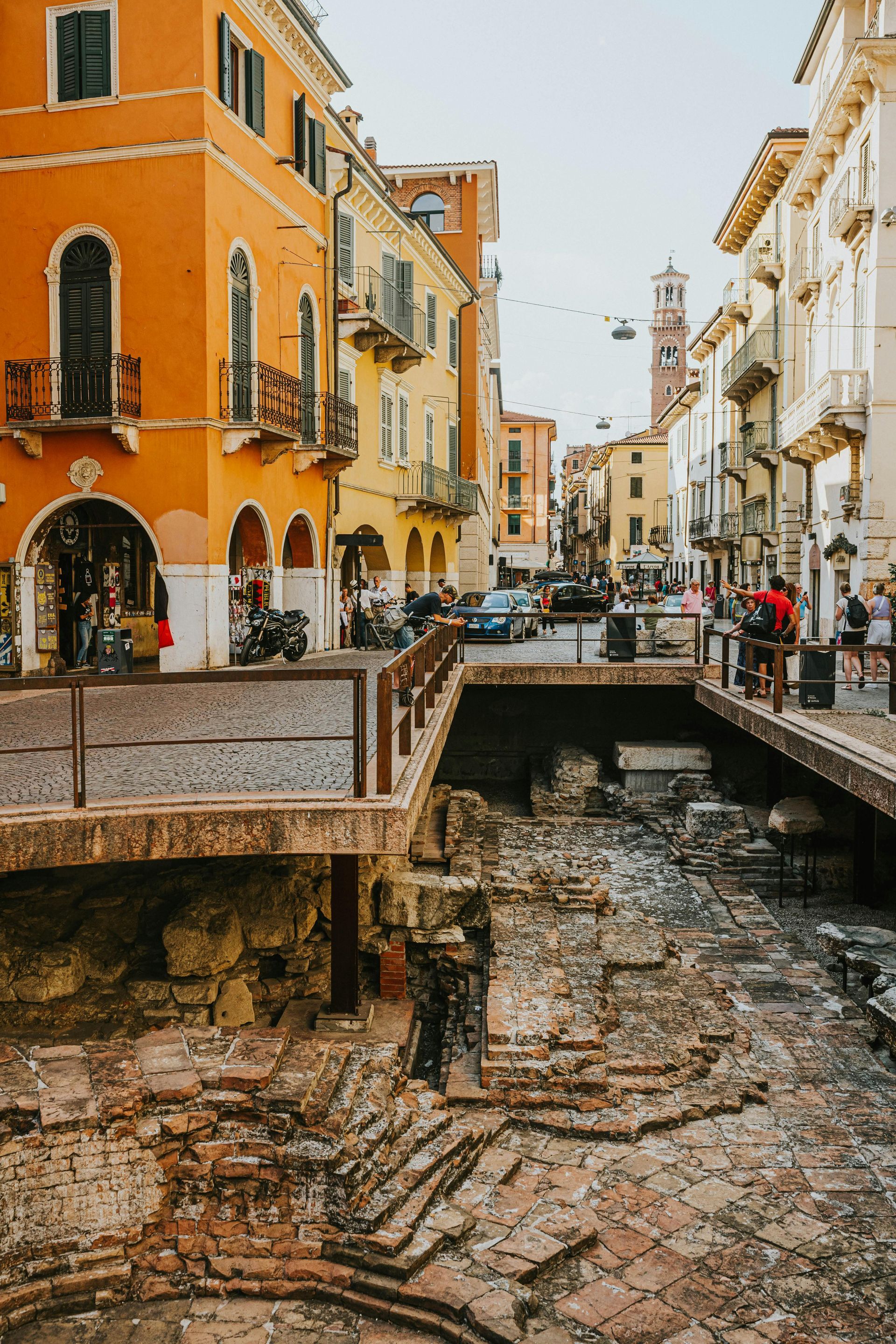 A group of people are walking down a narrow street in Verona, Italy.