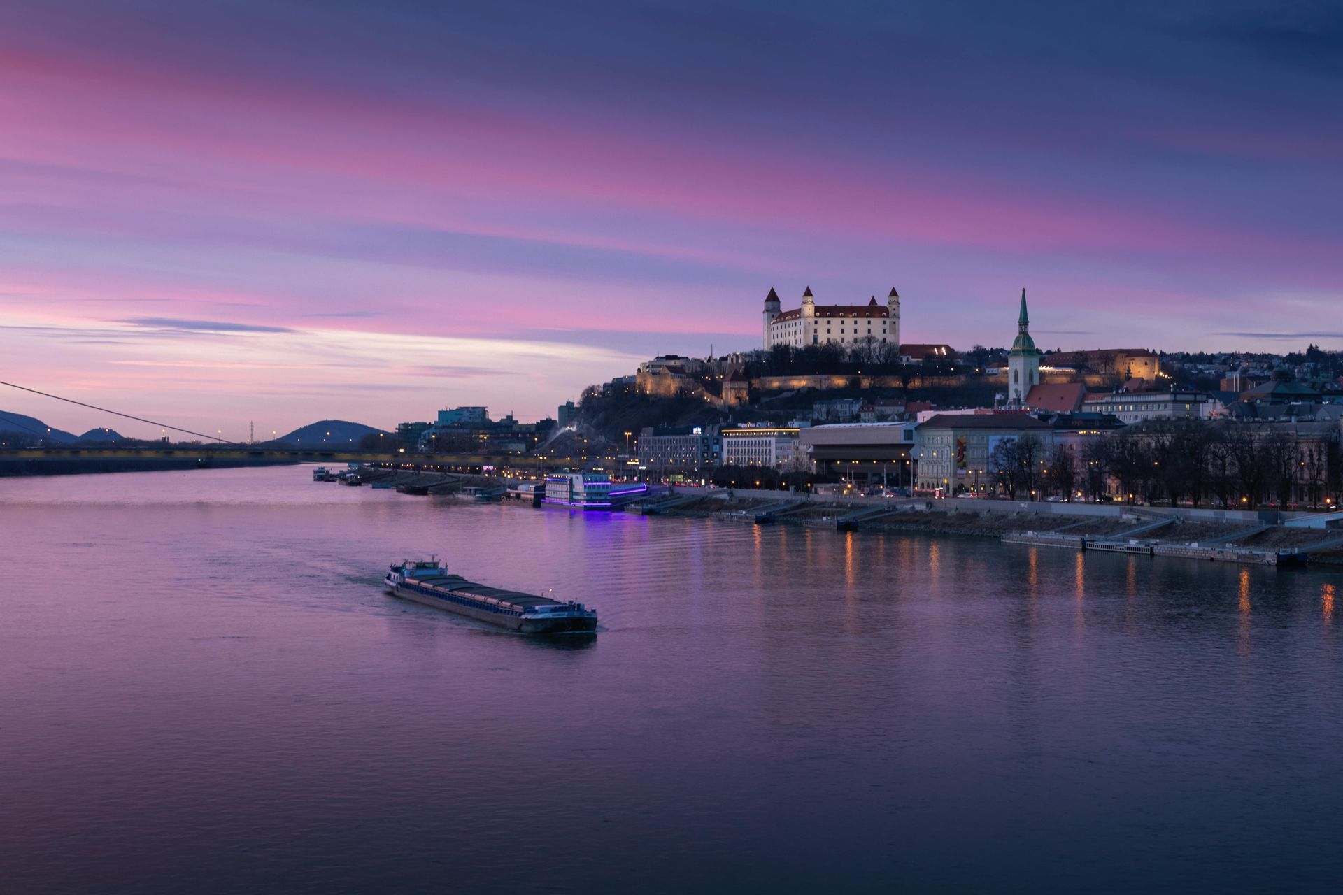 A boat is floating on The Danube River in front of a castle.