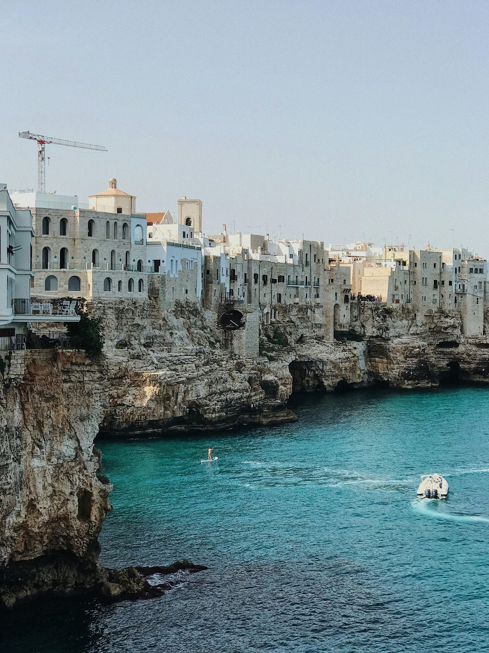 A boat is floating on the water near Polignano a Mare in Puglia, Italy.