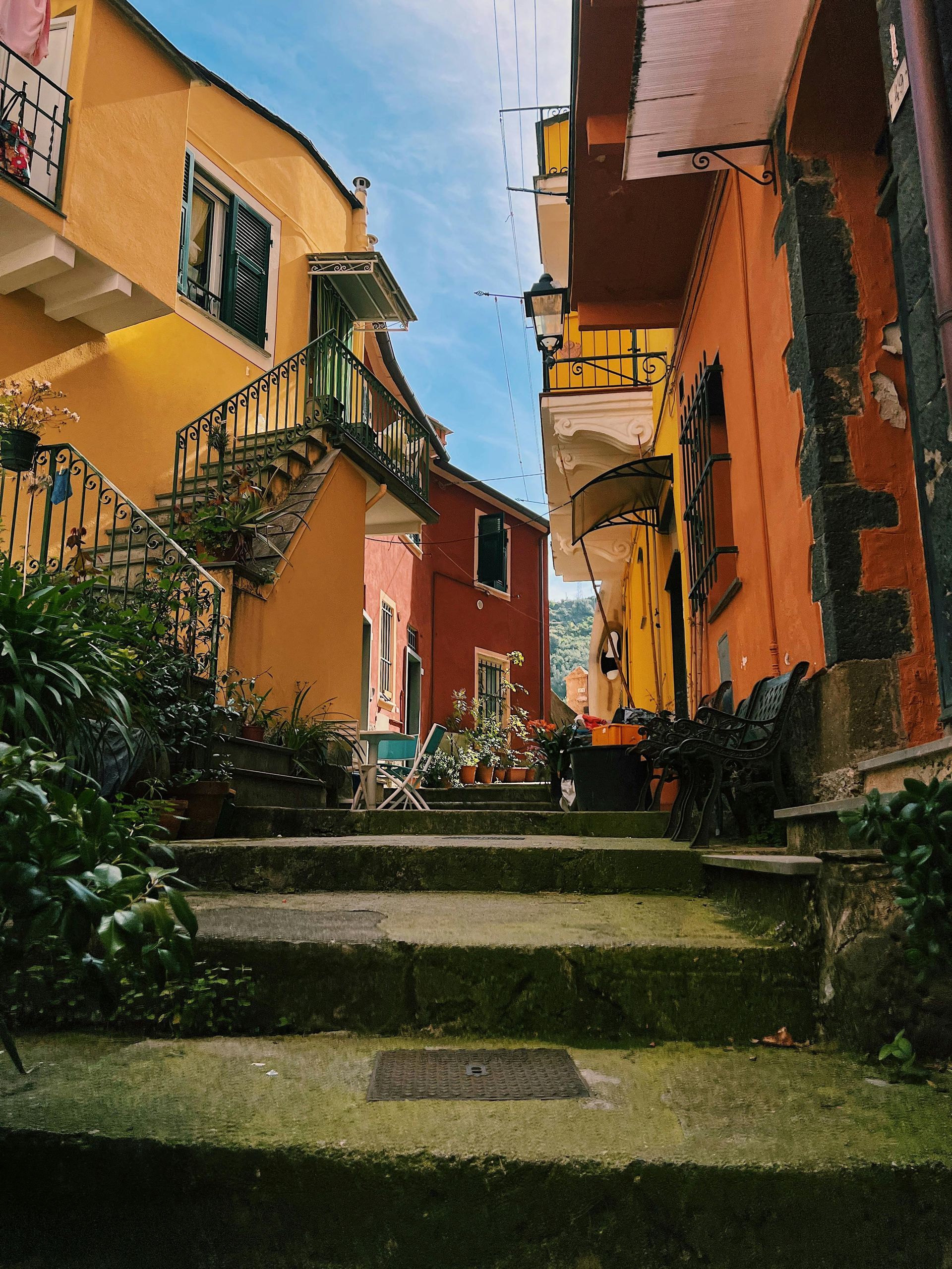 A narrow alleyway between two buildings with stairs leading up to the in Cinque Terre, Italy.